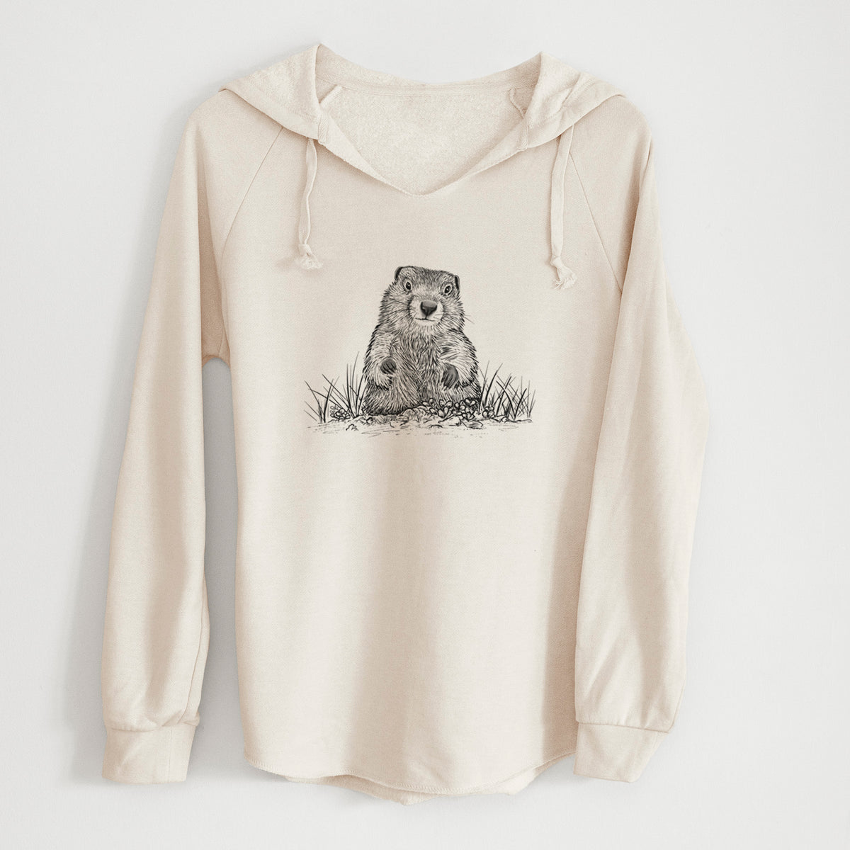 Bone cream women's Cali Wave hooded sweatshirt laid flat, printed with a black ink illustration of a groundhog peeking out of its burrow among grass.