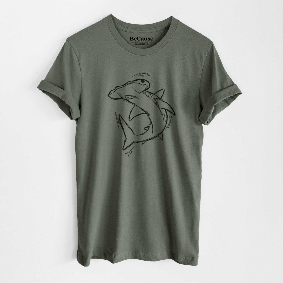 Military green lightweight cotton t-shirt laid flat, printed with a black ink illustration of a hammerhead shark swimming in a curve.