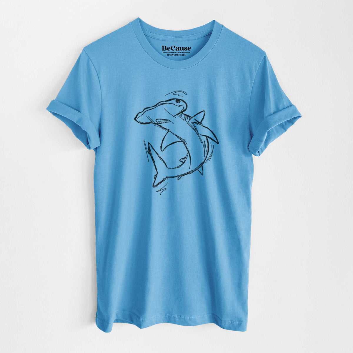 Ocean blue lightweight cotton t-shirt laid flat, printed with a black ink illustration of a hammerhead shark swimming in a curve.