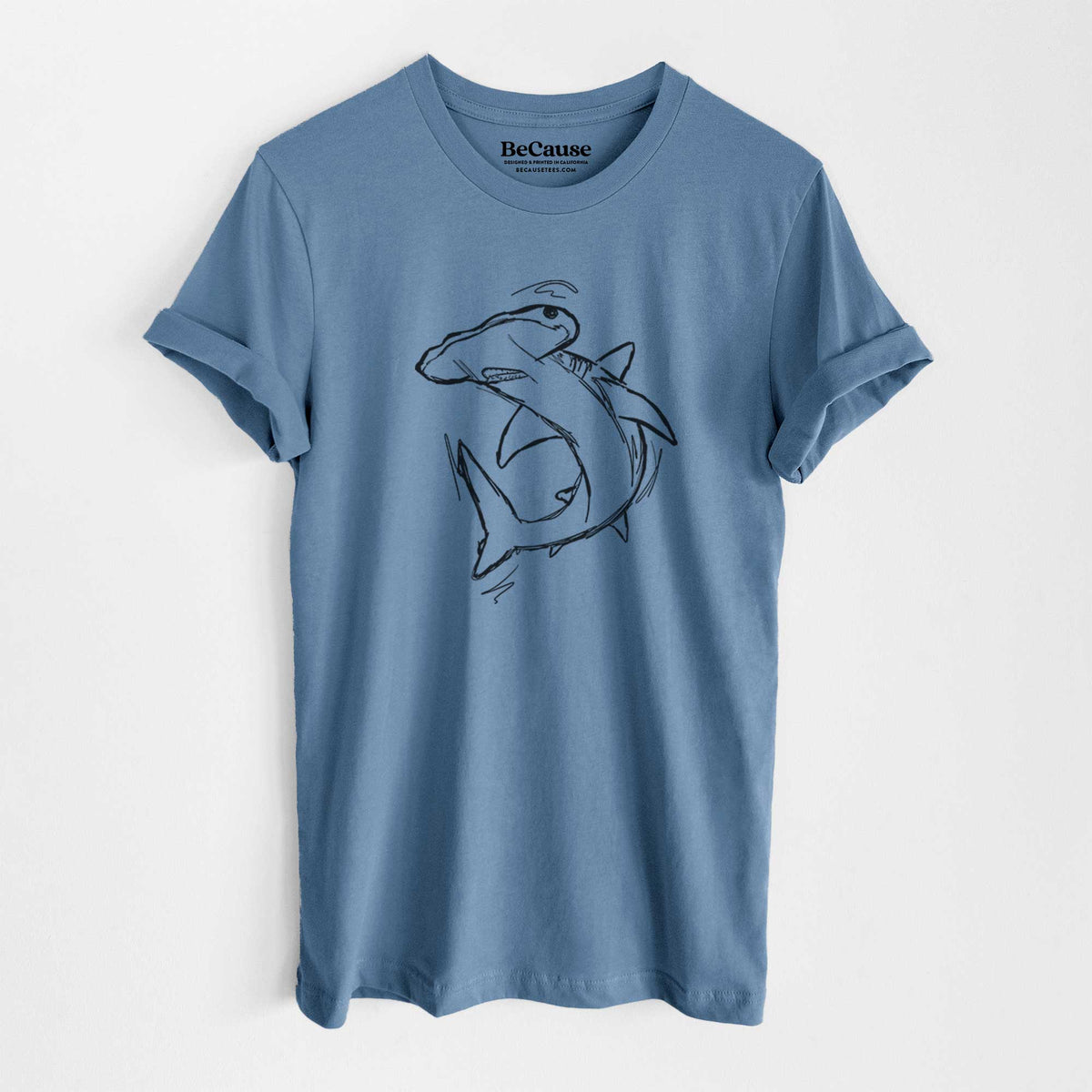 Steel blue lightweight cotton t-shirt laid flat, printed with a black ink illustration of a hammerhead shark swimming in a curve.