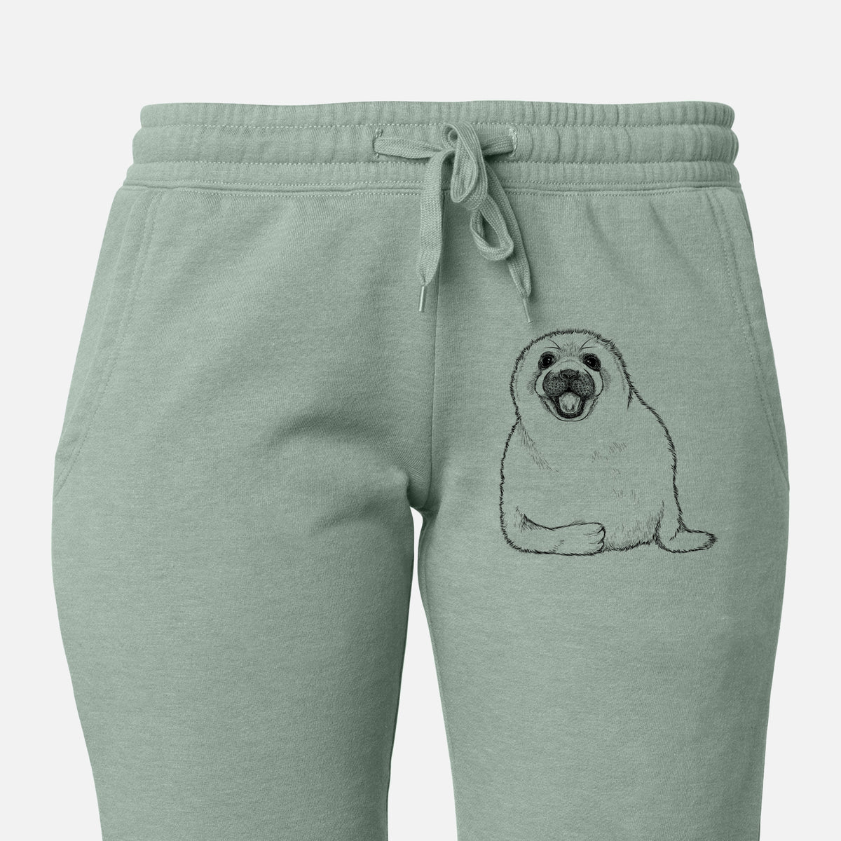 Front of sage green Cali Wave sweatpants, printed with a black ink illustration of a smiling harp seal pup lying down on the leg.