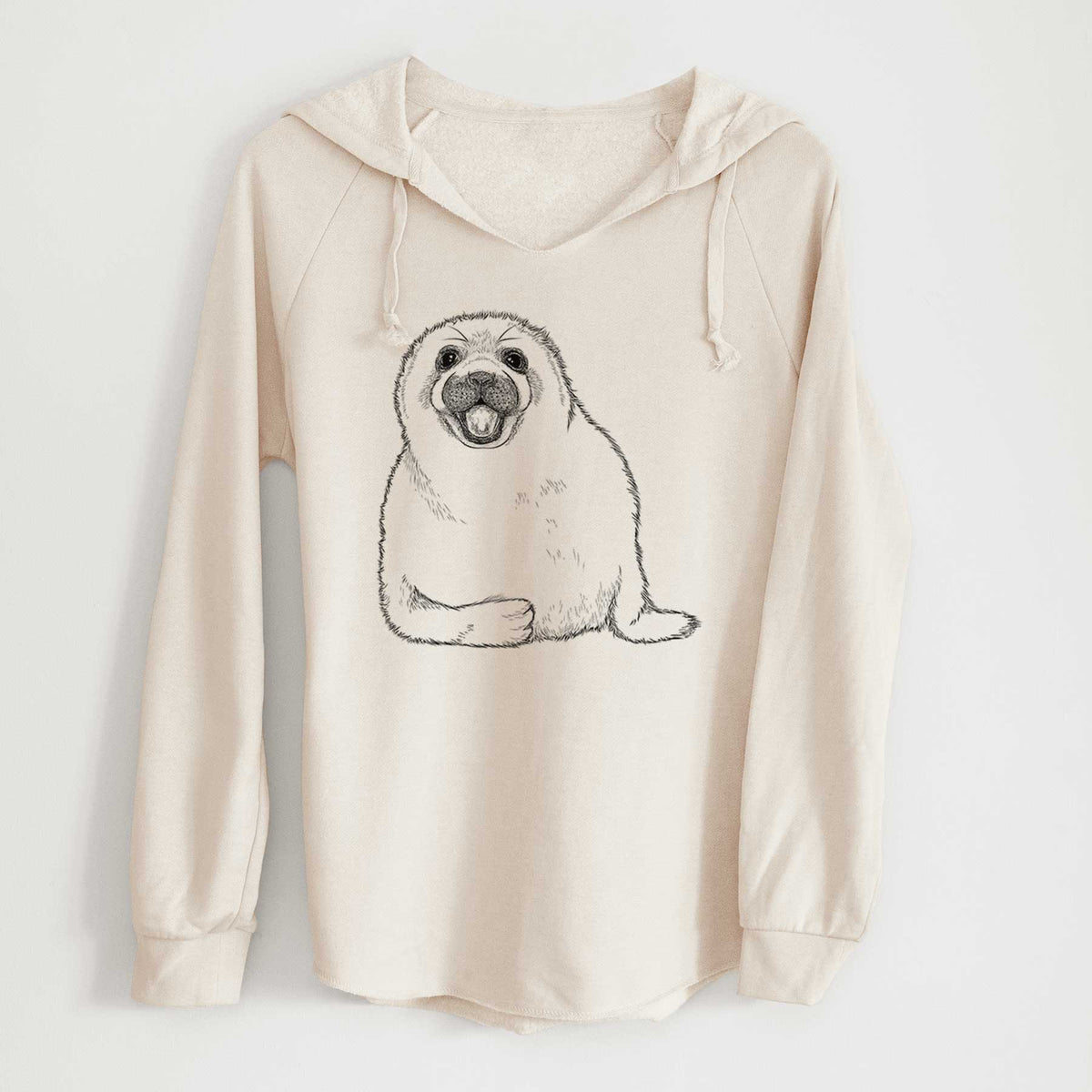 Bone cream women's Cali Wave hooded sweatshirt laid flat, printed with a black ink illustration of a smiling harp seal pup lying down.