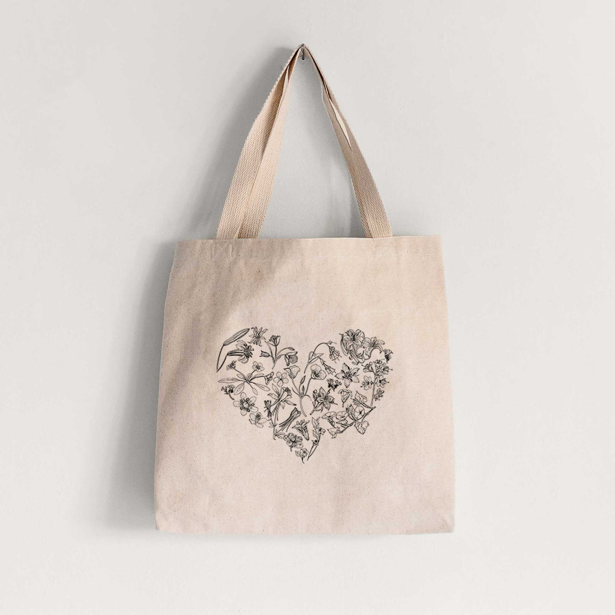 Natural canvas tote bag printed with a heart shape filled with black ink California mountain wildflowers.