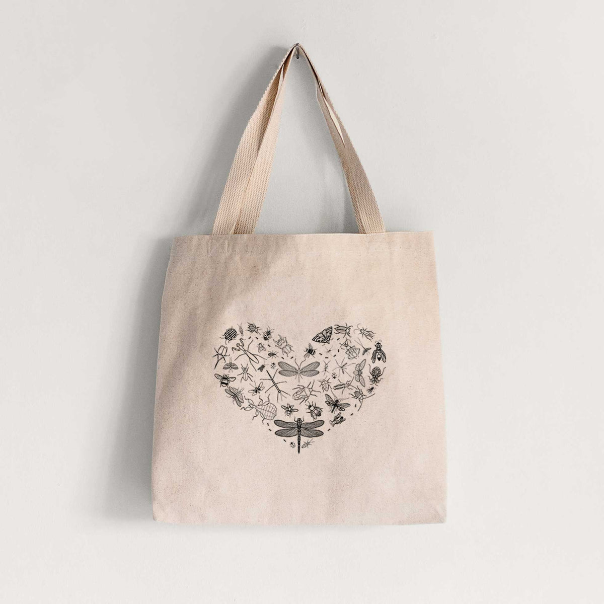 Natural canvas tote bag printed with a heart shape filled with small black ink insects, including dragonflies, beetles and bees.