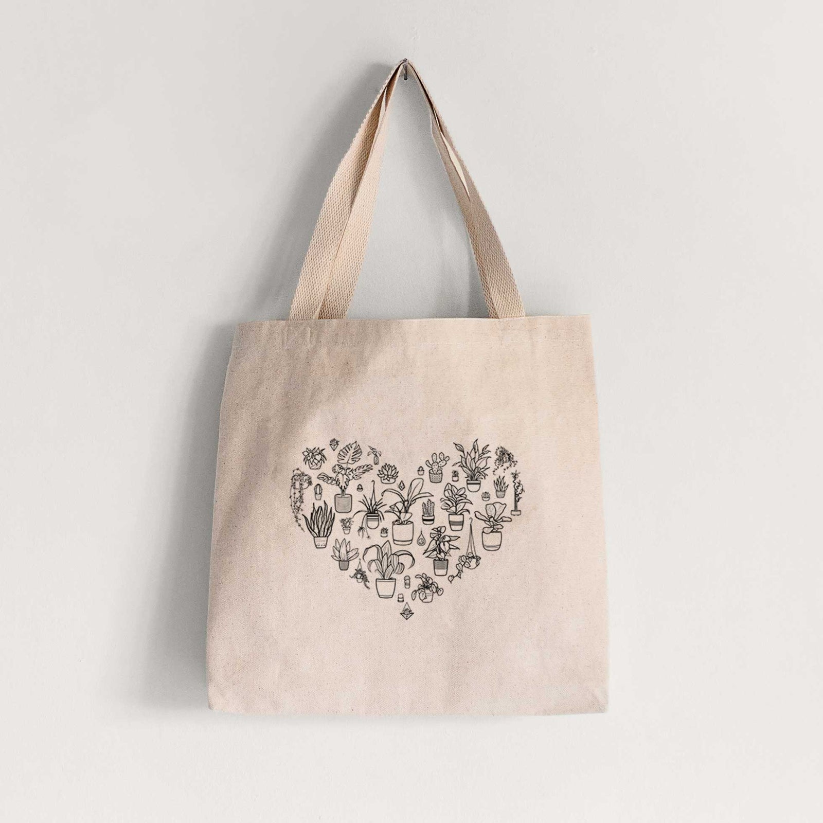 Natural canvas tote bag printed with a heart shape filled with black ink potted houseplants.