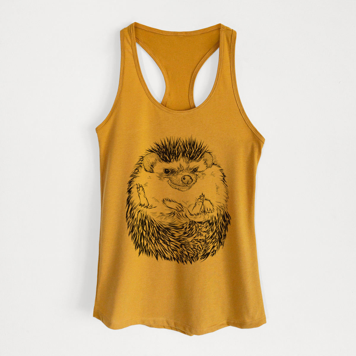 Gold women's racerback tank top laid flat, printed with a detailed black ink illustration of a hedgehog curled up and facing forward.