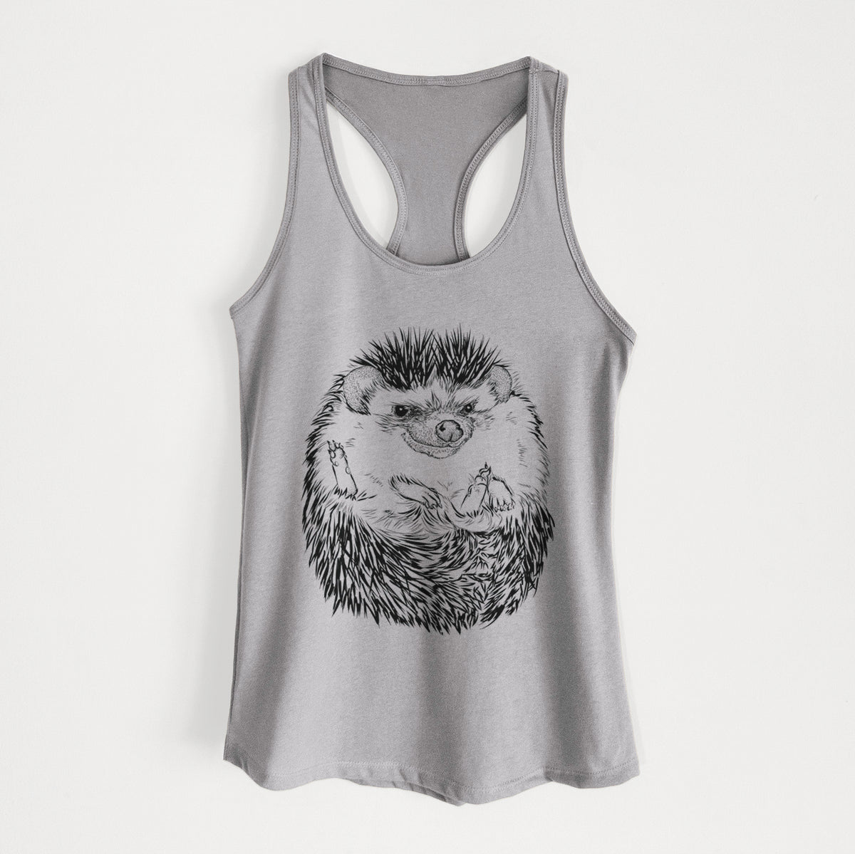 Heather grey women's racerback tank top laid flat, printed with a detailed black ink illustration of a hedgehog curled up and facing forward.