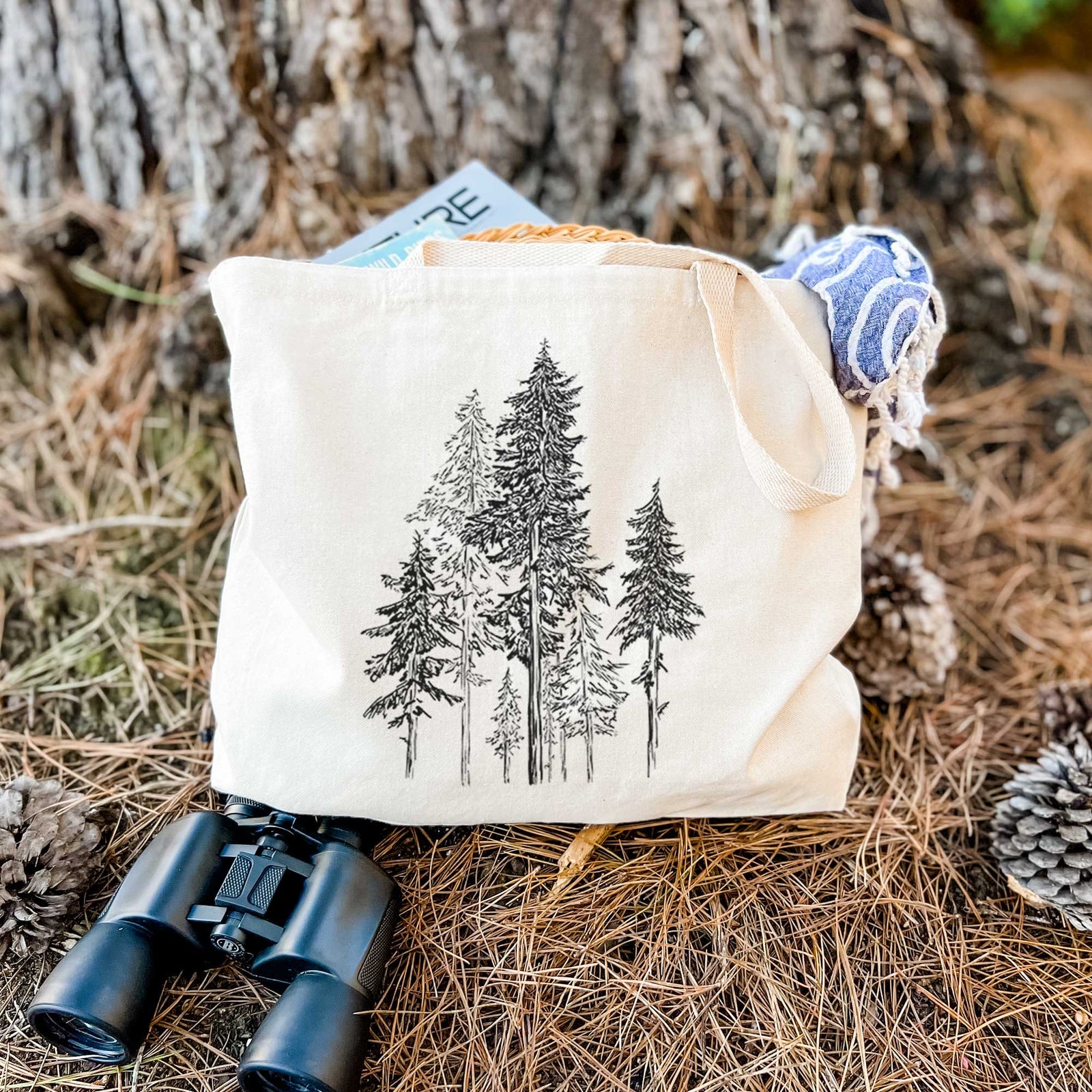 Natural canvas tote bag printed with a black ink illustration of a forest of tall hemlock trees.