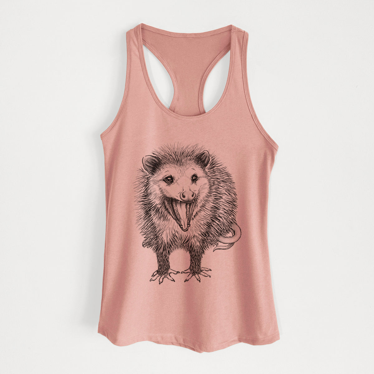 Desert pink women's racerback tank top laid flat, printed with a detailed black ink illustration of an opossum standing and facing forward, mouth open wide in a hiss, with shaggy fur and its tail curled behind.