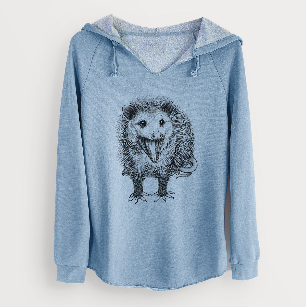 Misty blue women's Cali Wave hooded sweatshirt laid flat, with a crossover hood, drawcords and curved hem, printed with a detailed black ink illustration of an opossum standing and facing forward, mouth open wide in a hiss, with shaggy fur and its tail curled behind.