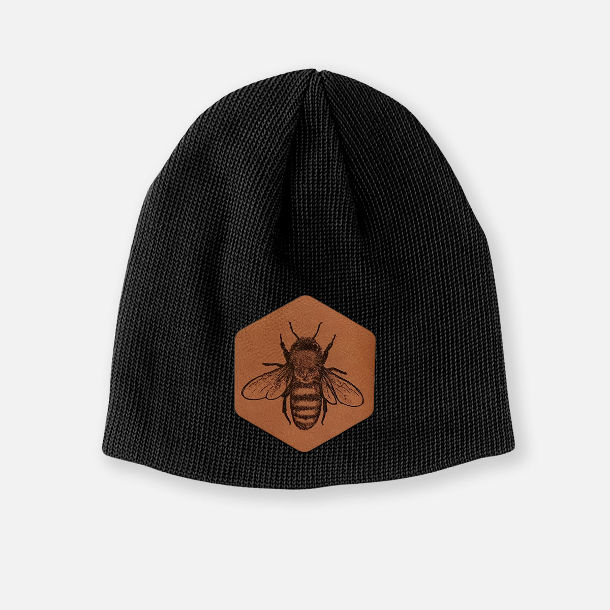 Black cotton beanie with a brown leather patch engraved with a honey bee on the front.