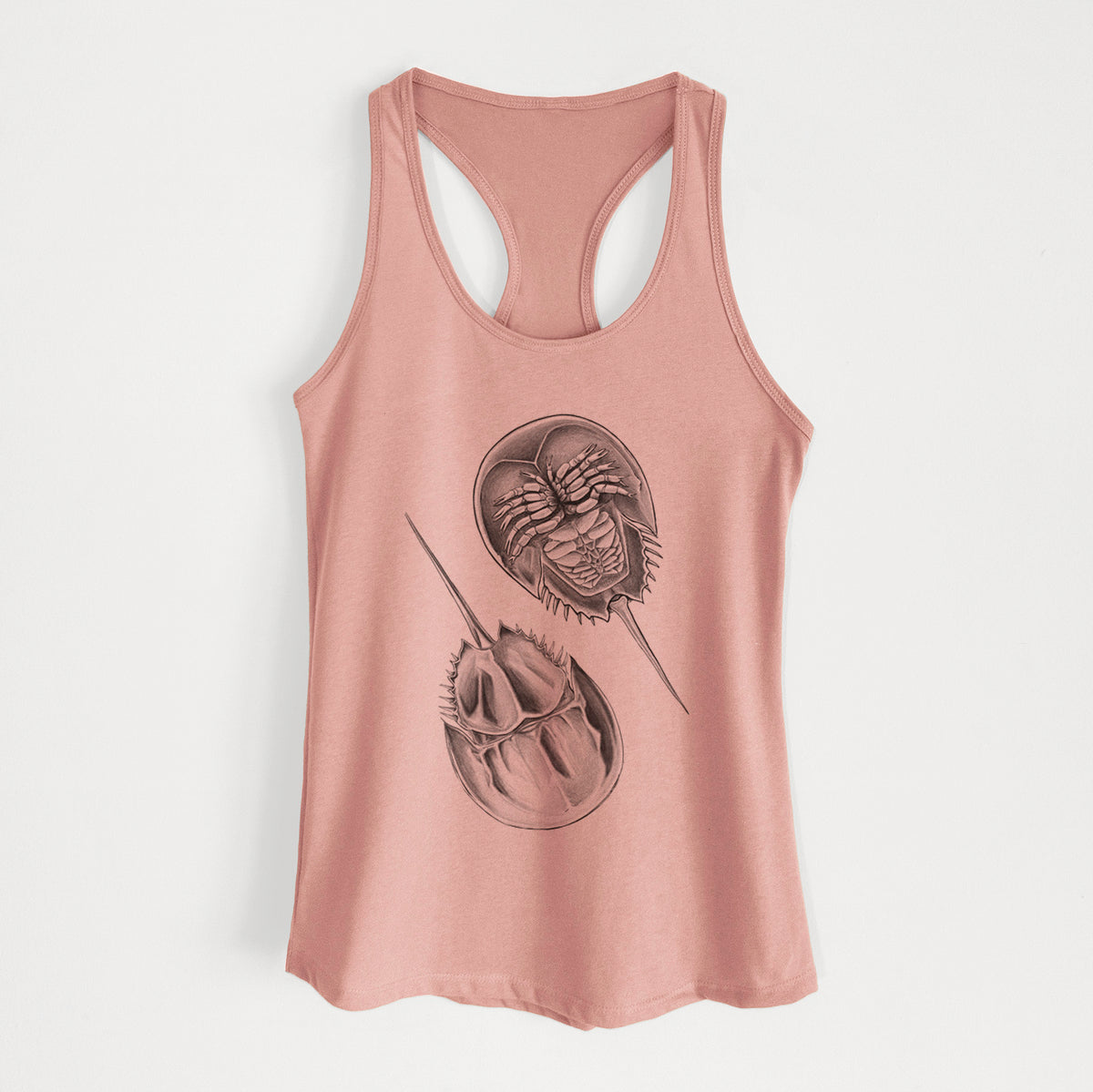 Desert pink women's racerback tank top laid flat, printed with a detailed black ink illustration of two horseshoe crabs.
