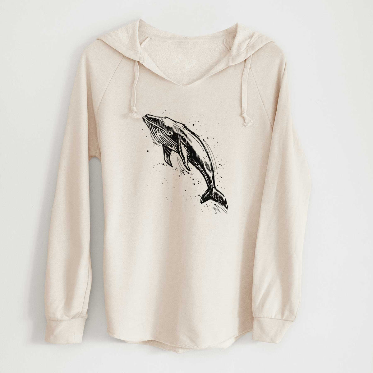 Bone cream women's Cali Wave hooded sweatshirt laid flat, printed with a black ink illustration of a humpback whale diving, with ink splatters.