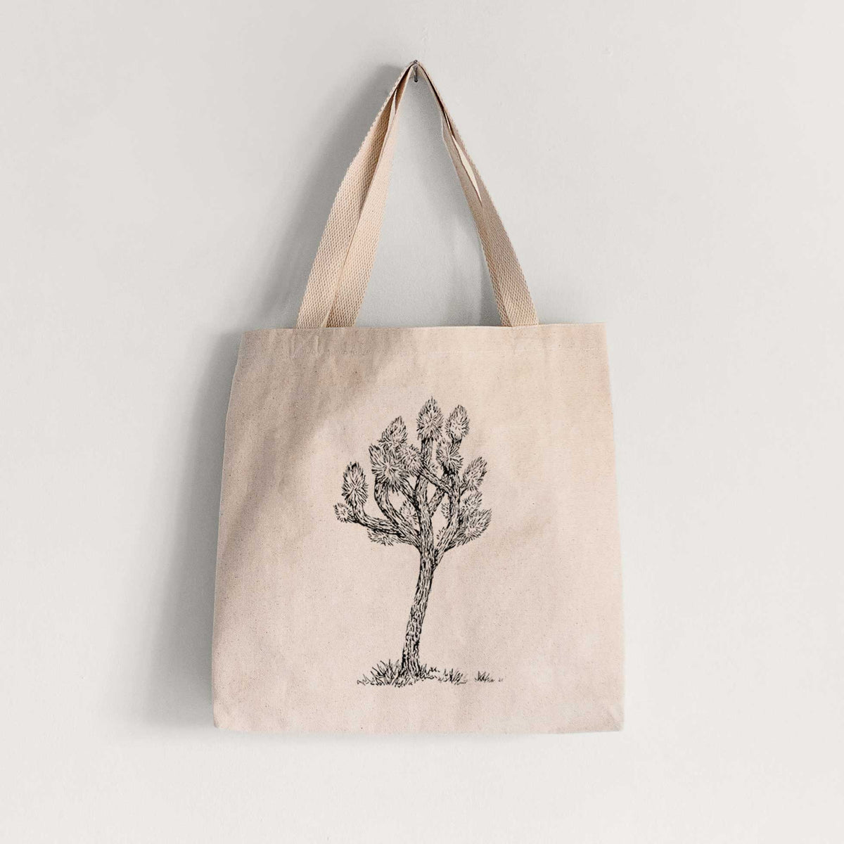 Natural canvas tote bag printed with a detailed black ink illustration of a Joshua tree.