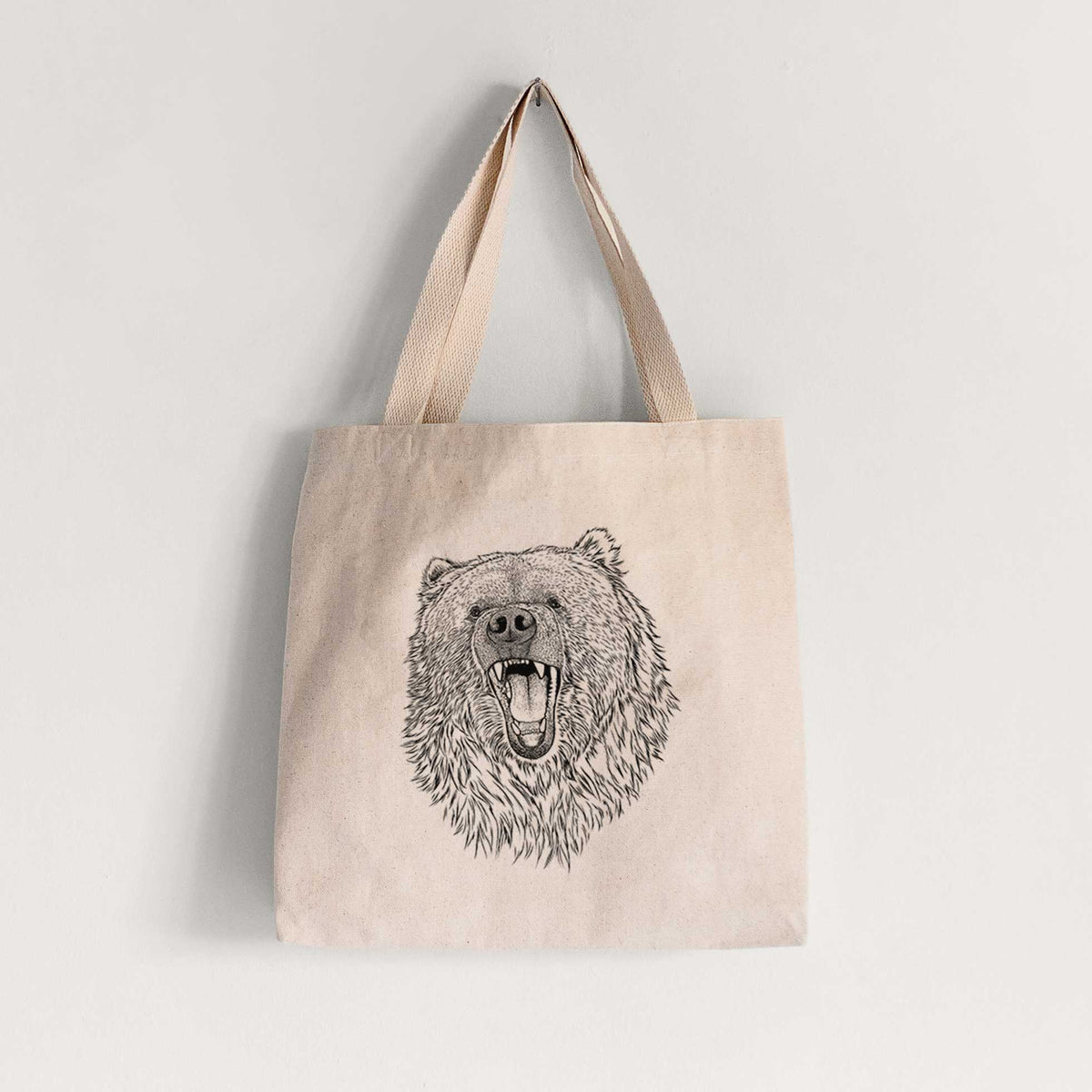 Natural canvas tote bag printed with a detailed black ink portrait of a roaring Kodiak bear facing forward.