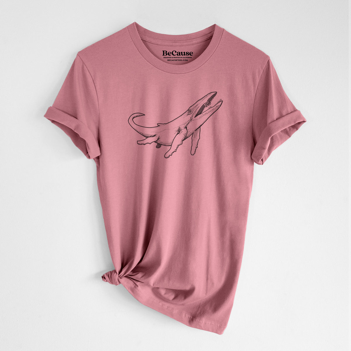 Mauve pink lightweight cotton t-shirt laid flat with the sleeves rolled, printed with a black ink illustration of a Kronosaurus marine reptile swimming.