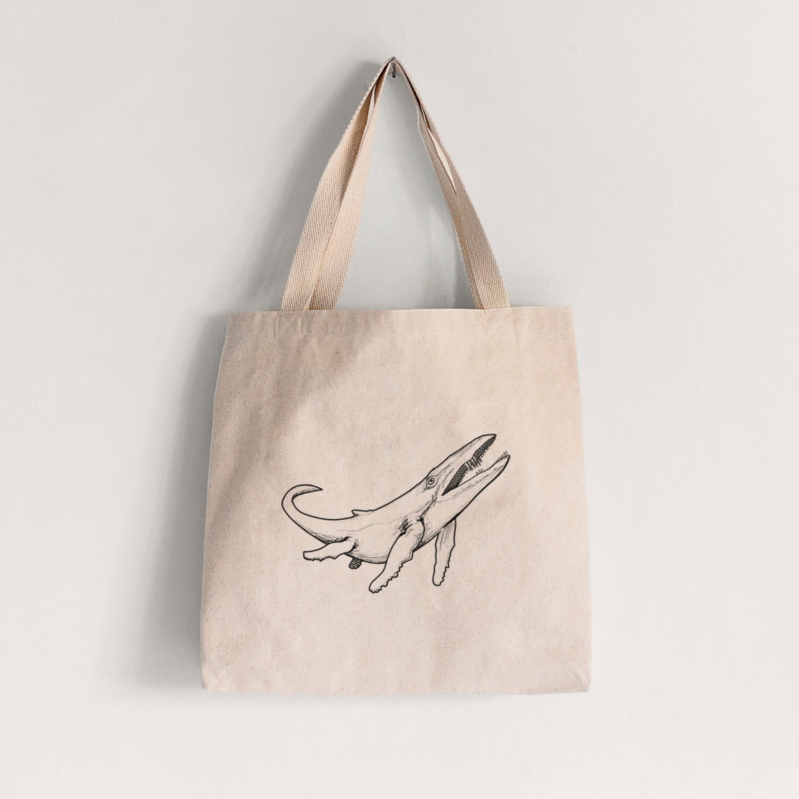 Natural canvas tote bag printed with a black ink illustration of a Kronosaurus marine reptile swimming.