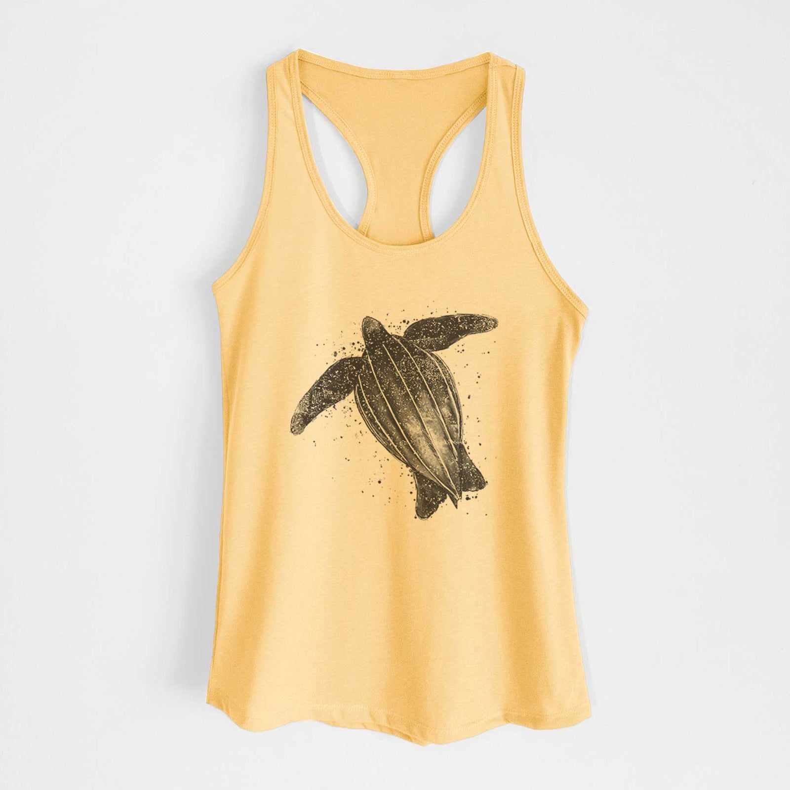 Banana cream women's racerback tank top laid flat, printed with a black ink illustration of a leatherback sea turtle swimming, with ink splatters.