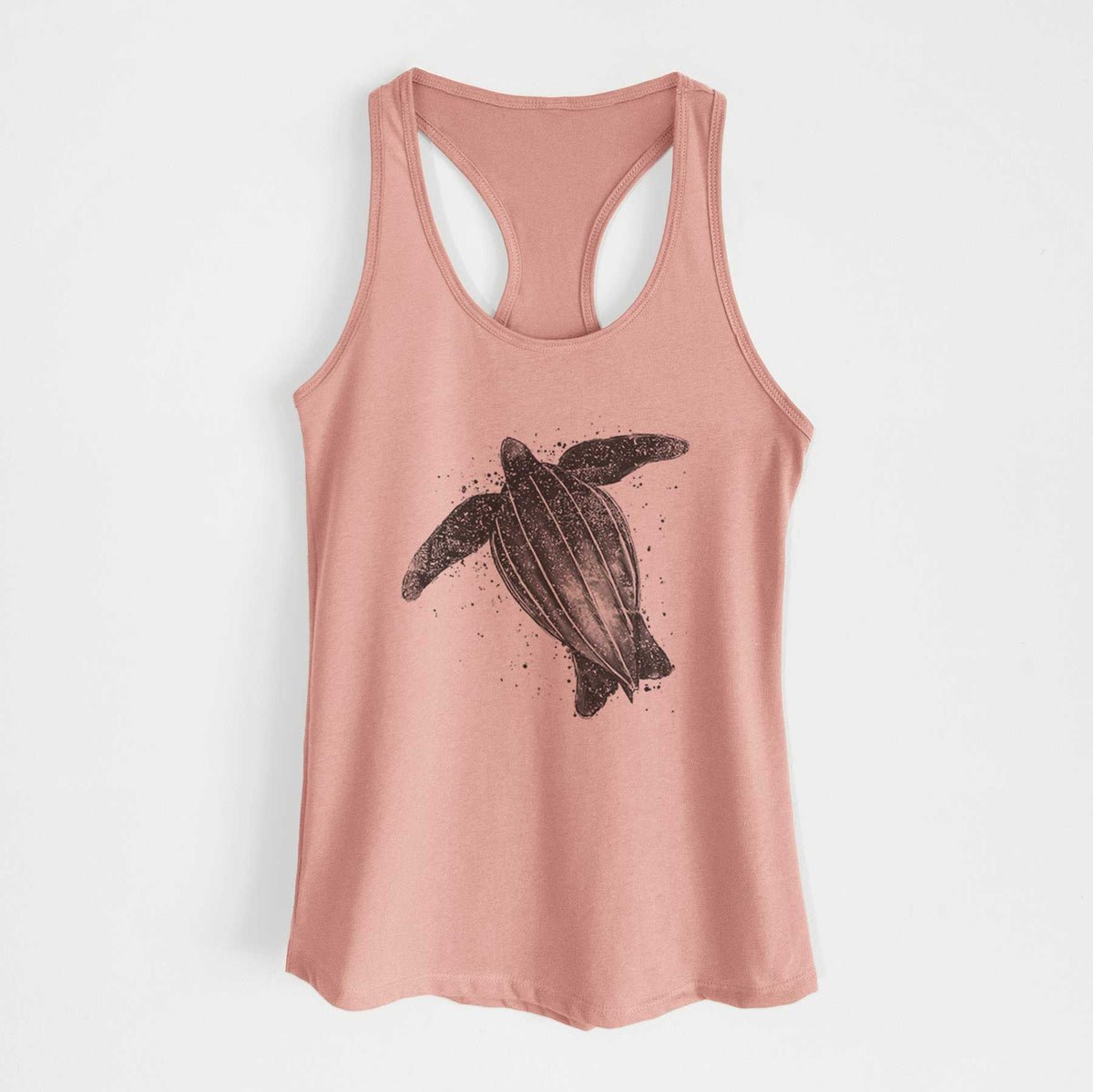 Desert pink women's racerback tank top laid flat, printed with a black ink illustration of a leatherback sea turtle swimming, with ink splatters.