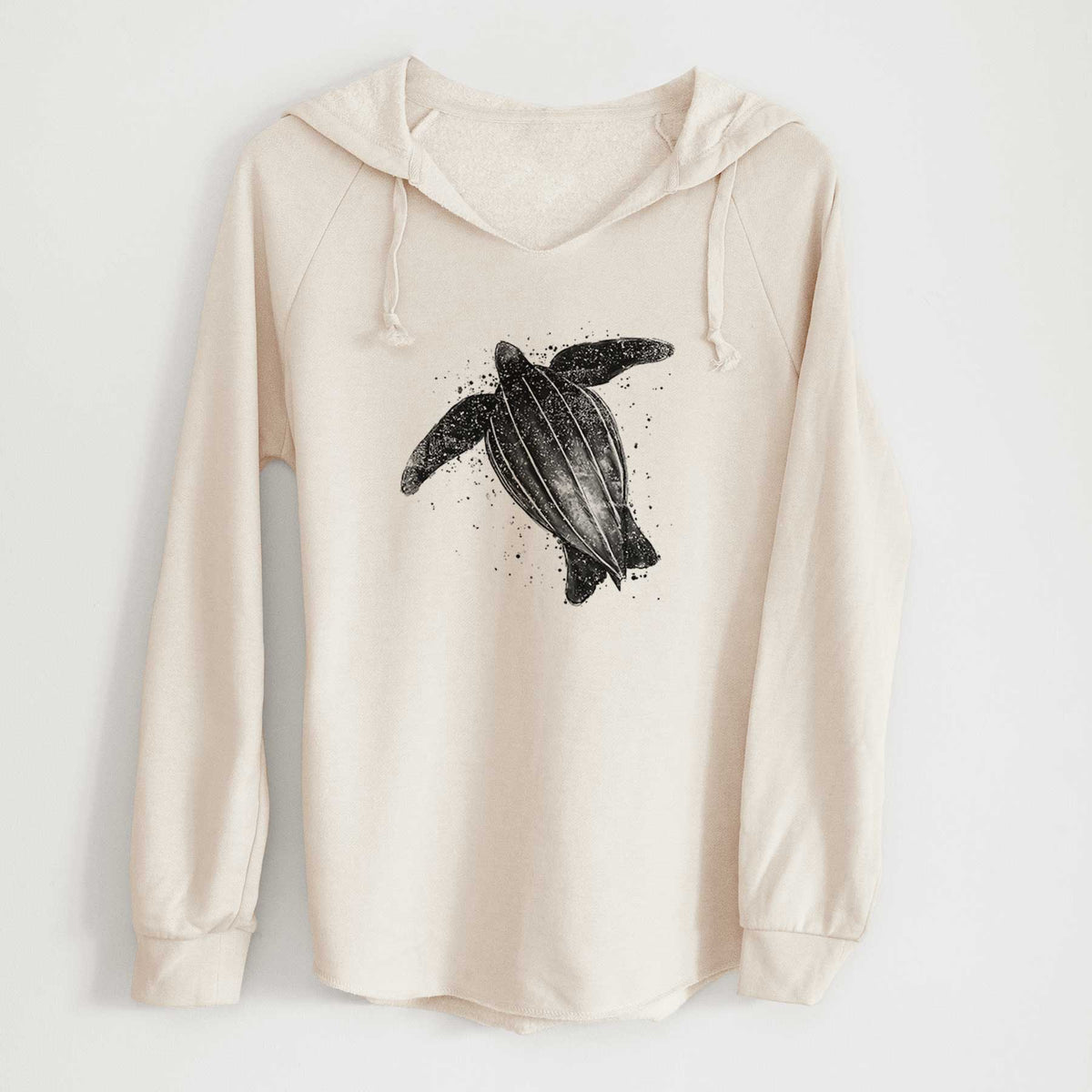 Bone cream women's Cali Wave hooded sweatshirt laid flat, printed with a black ink illustration of a leatherback sea turtle swimming, with ink splatters.