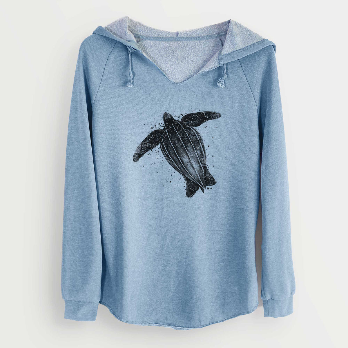 Misty blue women's Cali Wave hooded sweatshirt laid flat, printed with a black ink illustration of a leatherback sea turtle swimming, with ink splatters.