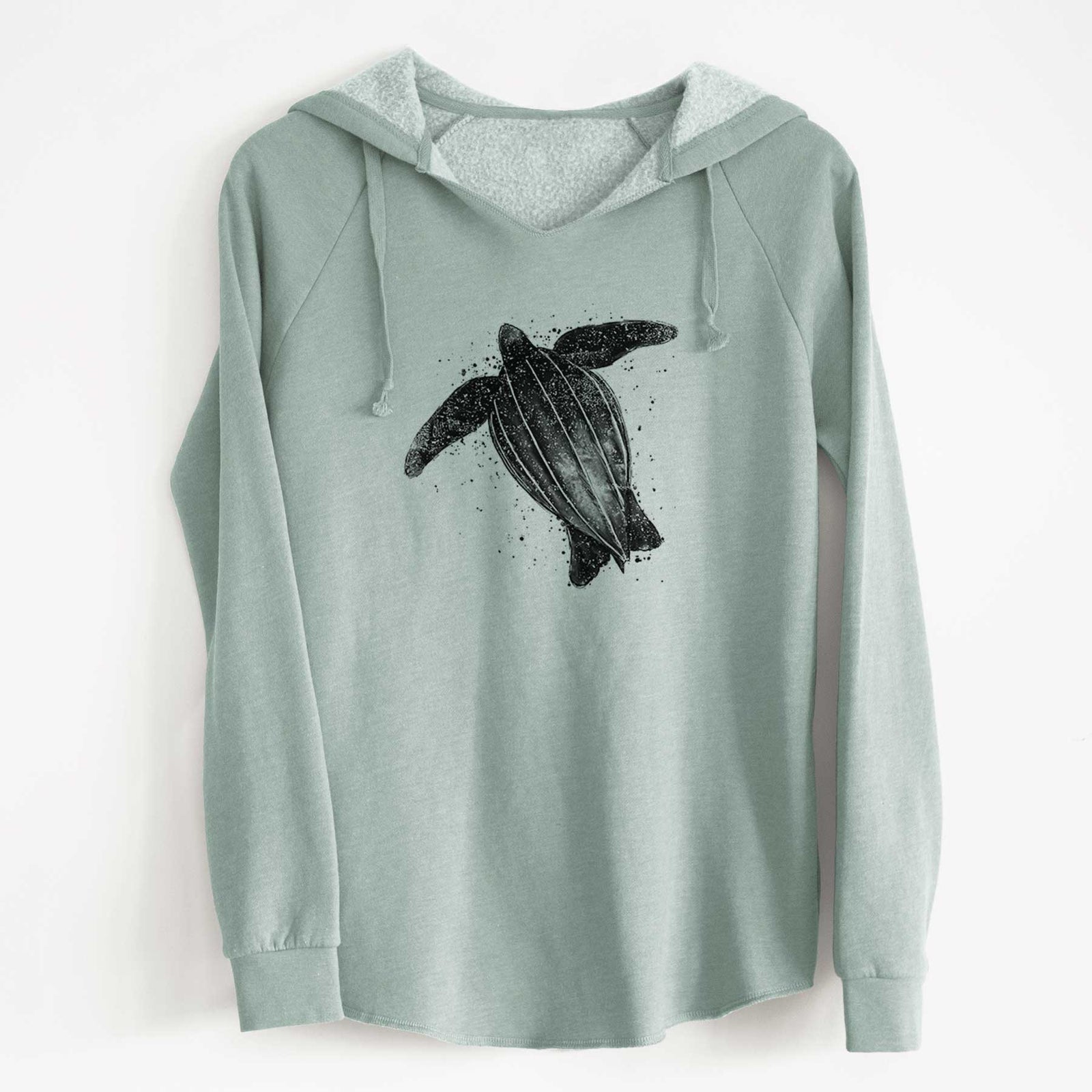 Sage green women's Cali Wave hooded sweatshirt laid flat, printed with a black ink illustration of a leatherback sea turtle swimming, with ink splatters.