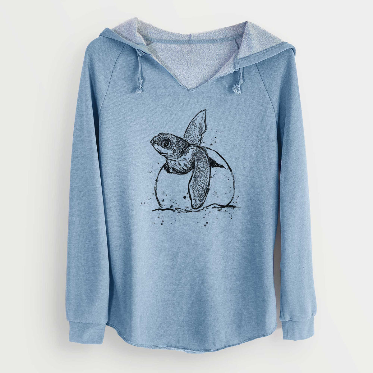 Misty blue women's Cali Wave hooded sweatshirt laid flat, printed with a black ink illustration of a leatherback sea turtle hatchling emerging from its egg.