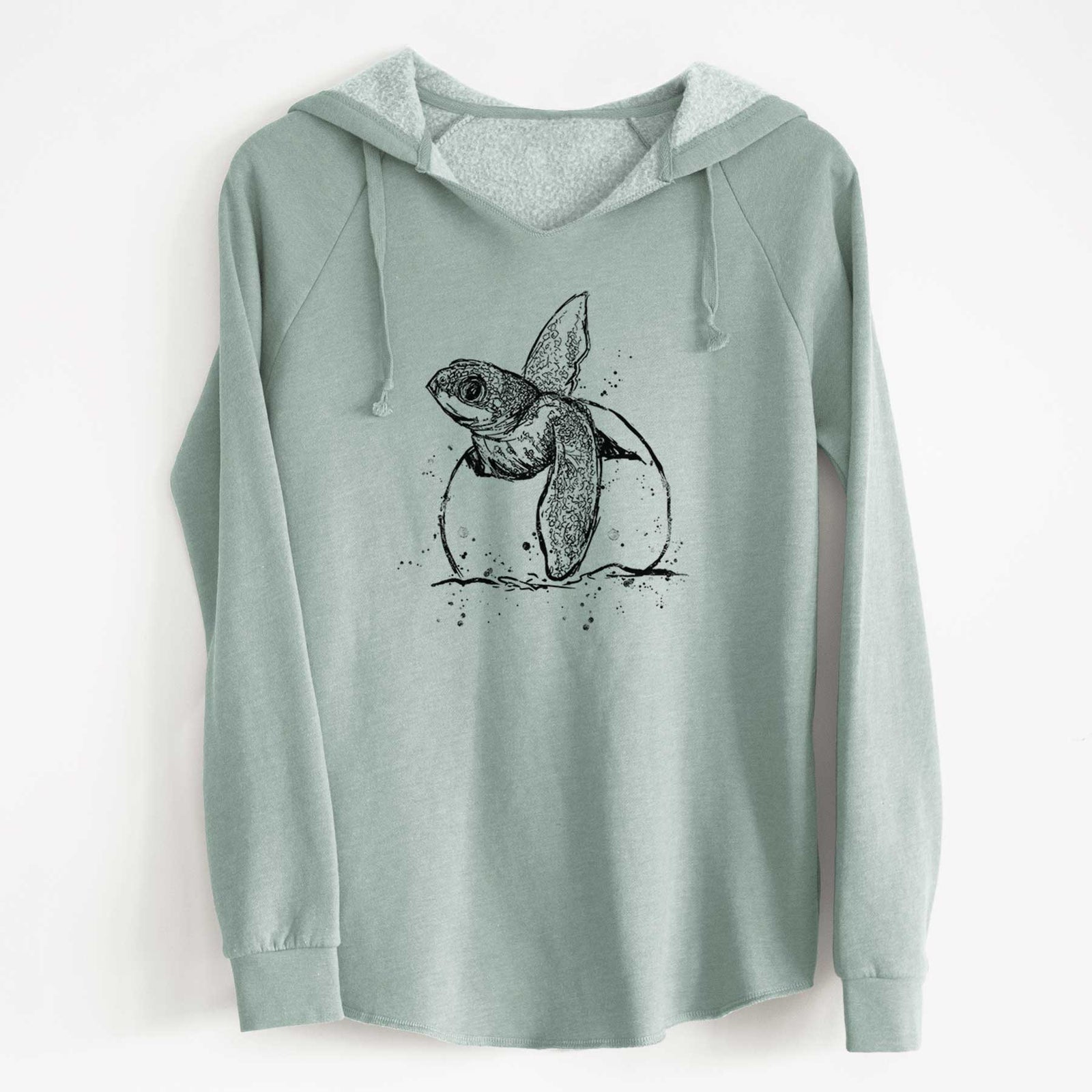 Sage green women's Cali Wave hooded sweatshirt laid flat, printed with a black ink illustration of a leatherback sea turtle hatchling emerging from its egg.