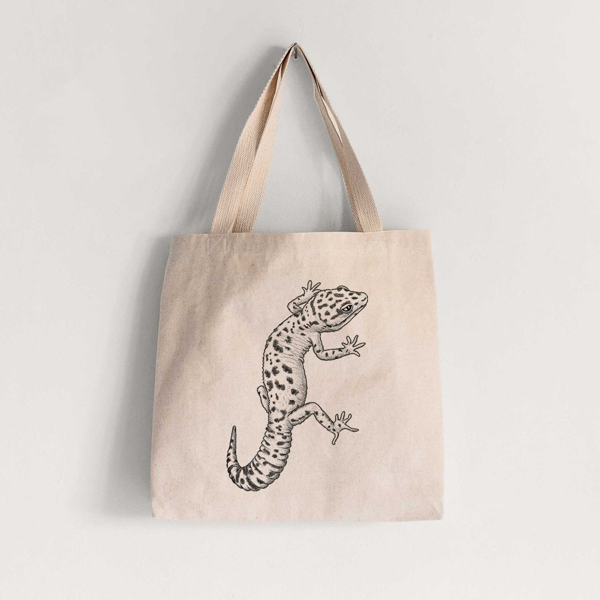 Natural canvas tote bag printed with a detailed black ink illustration of a spotted leopard gecko climbing.