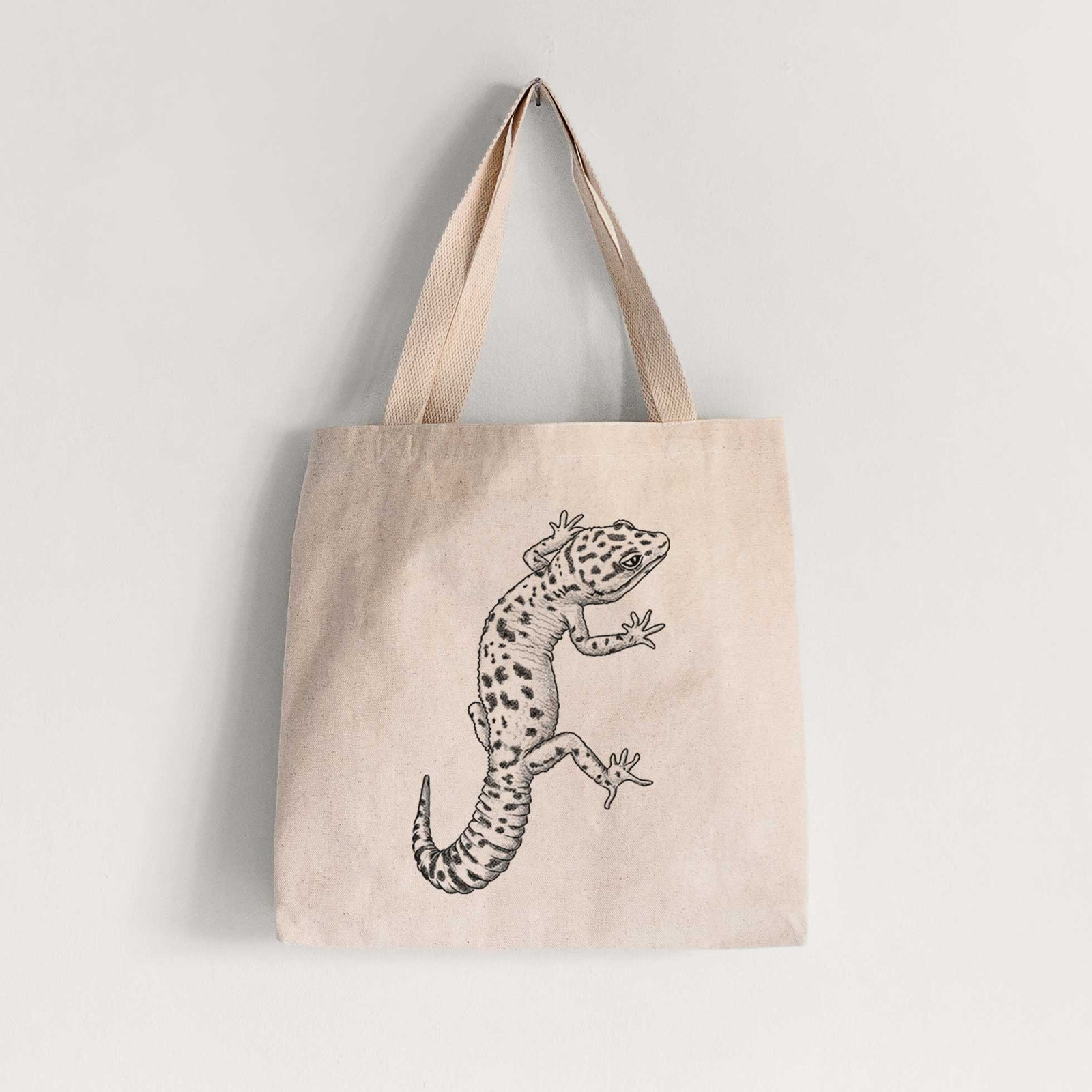 Natural canvas tote bag printed with a detailed black ink illustration of a spotted leopard gecko climbing.
