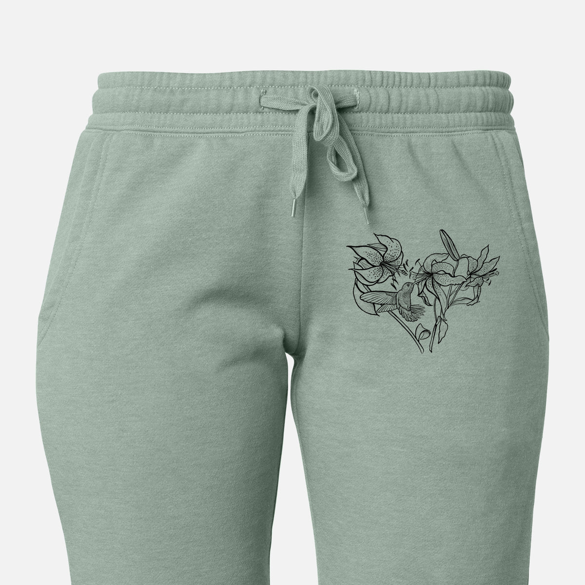 Front of sage green Cali Wave sweatpants, printed with a black ink line drawing of lilies and a hummingbird arranged in a heart shape on the leg.