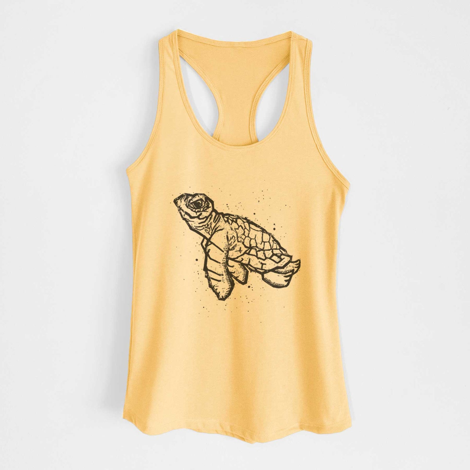 Banana cream women's racerback tank top laid flat, printed with a black linocut-style illustration of a baby sea turtle with a patterned shell and ink splatters.