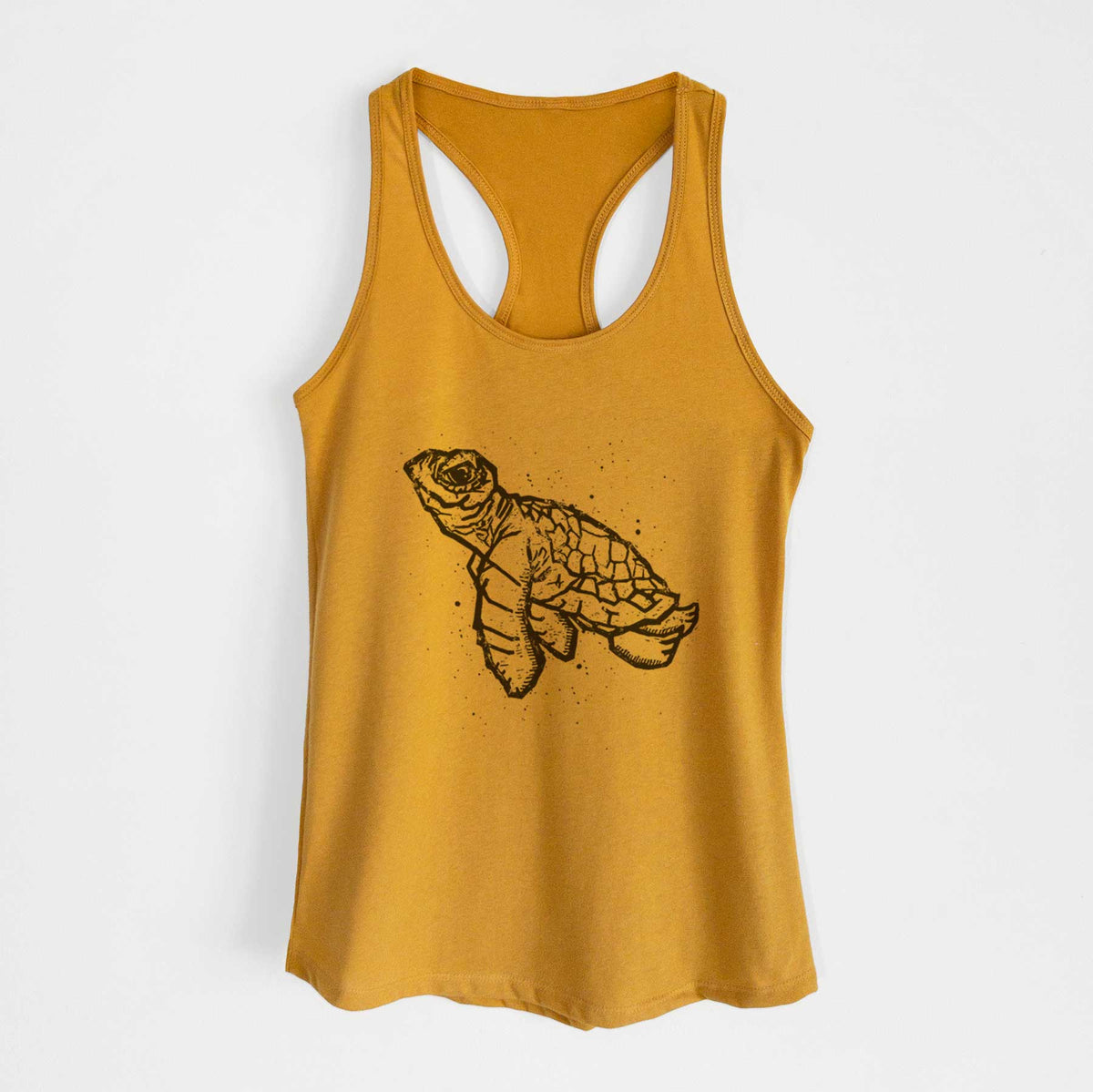 Gold women's racerback tank top laid flat, printed with a black linocut-style illustration of a baby sea turtle with a patterned shell and ink splatters.