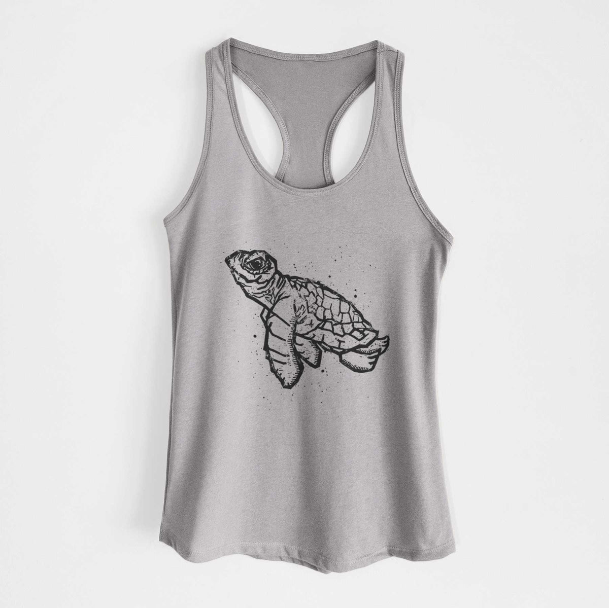 Heather grey women's racerback tank top laid flat, printed with a black linocut-style illustration of a baby sea turtle with a patterned shell and ink splatters.