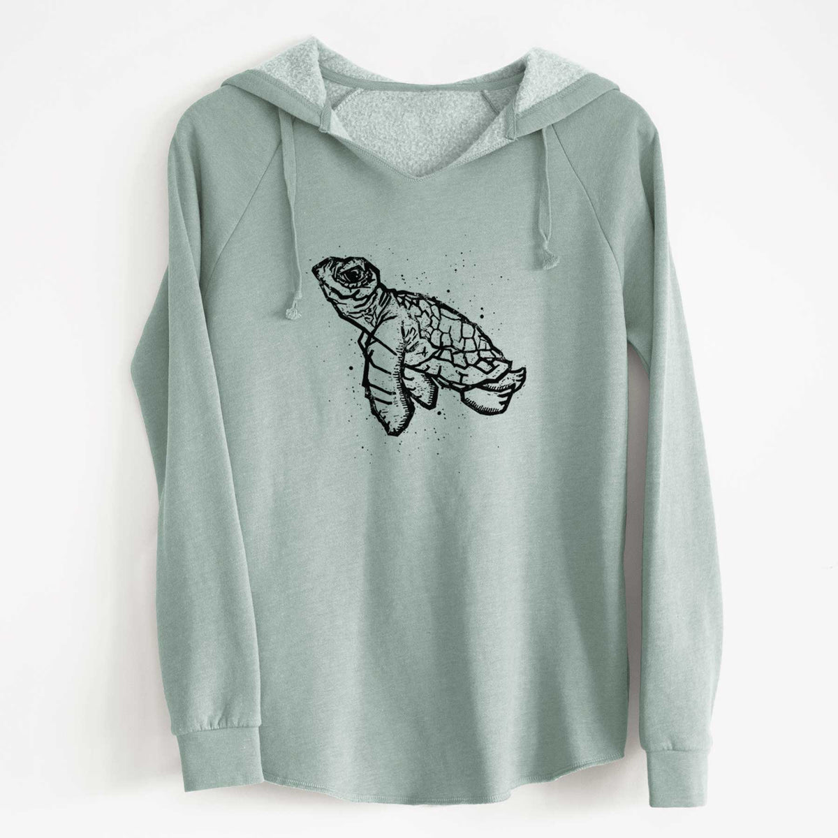 Sage green women's Cali Wave hooded sweatshirt laid flat, printed with a black linocut-style illustration of a baby sea turtle with a patterned shell and ink splatters.