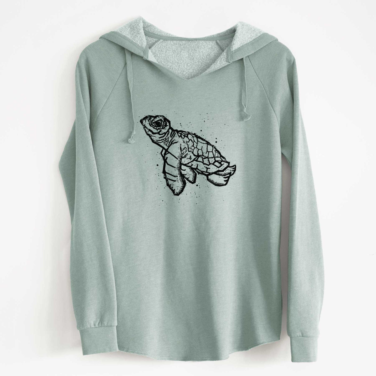Dusty rose women's Cali Wave hooded sweatshirt laid flat, printed with a black linocut-style illustration of a baby sea turtle with a patterned shell and ink splatters.