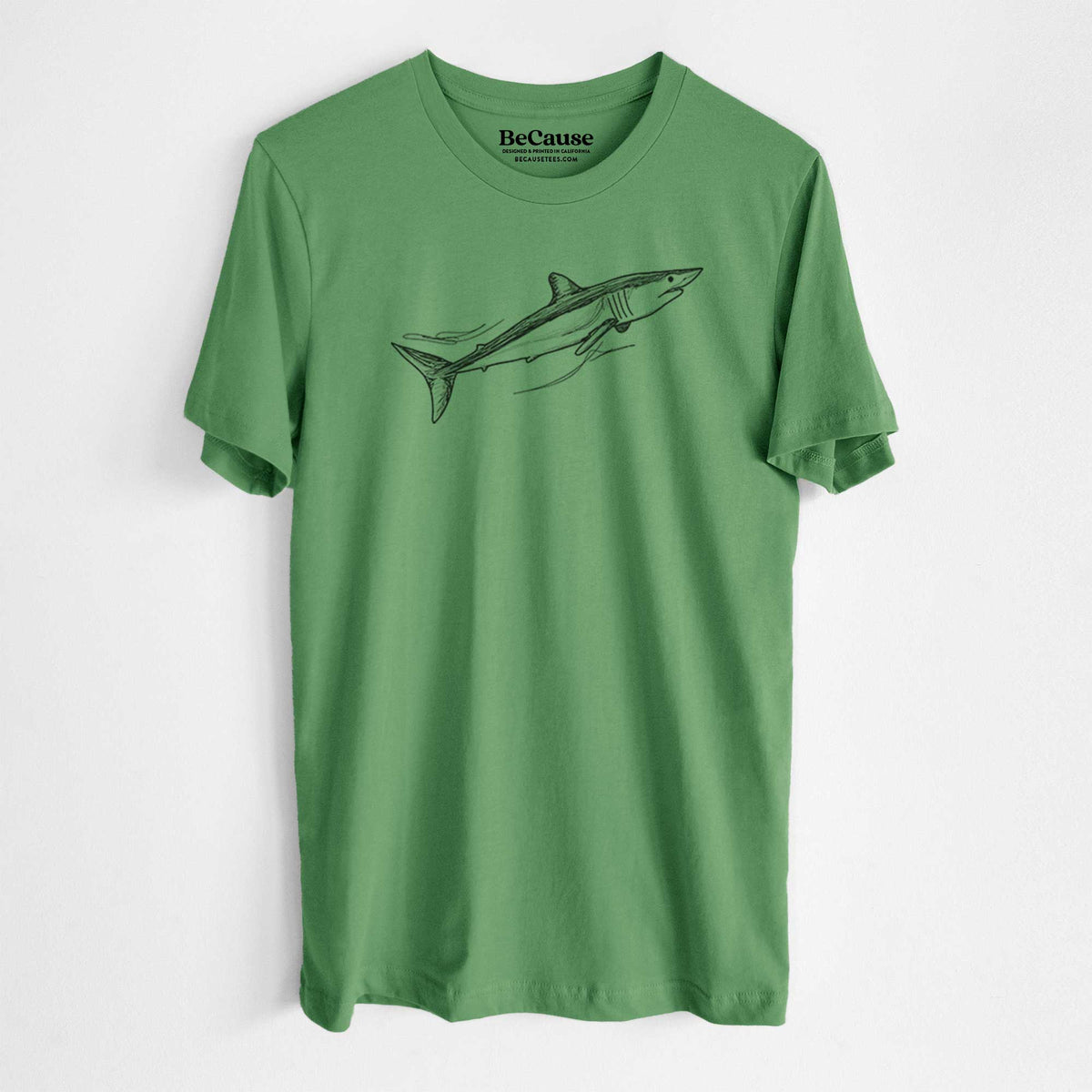 Leaf green lightweight cotton t-shirt laid flat, printed with a black ink illustration of a mako shark swimming.