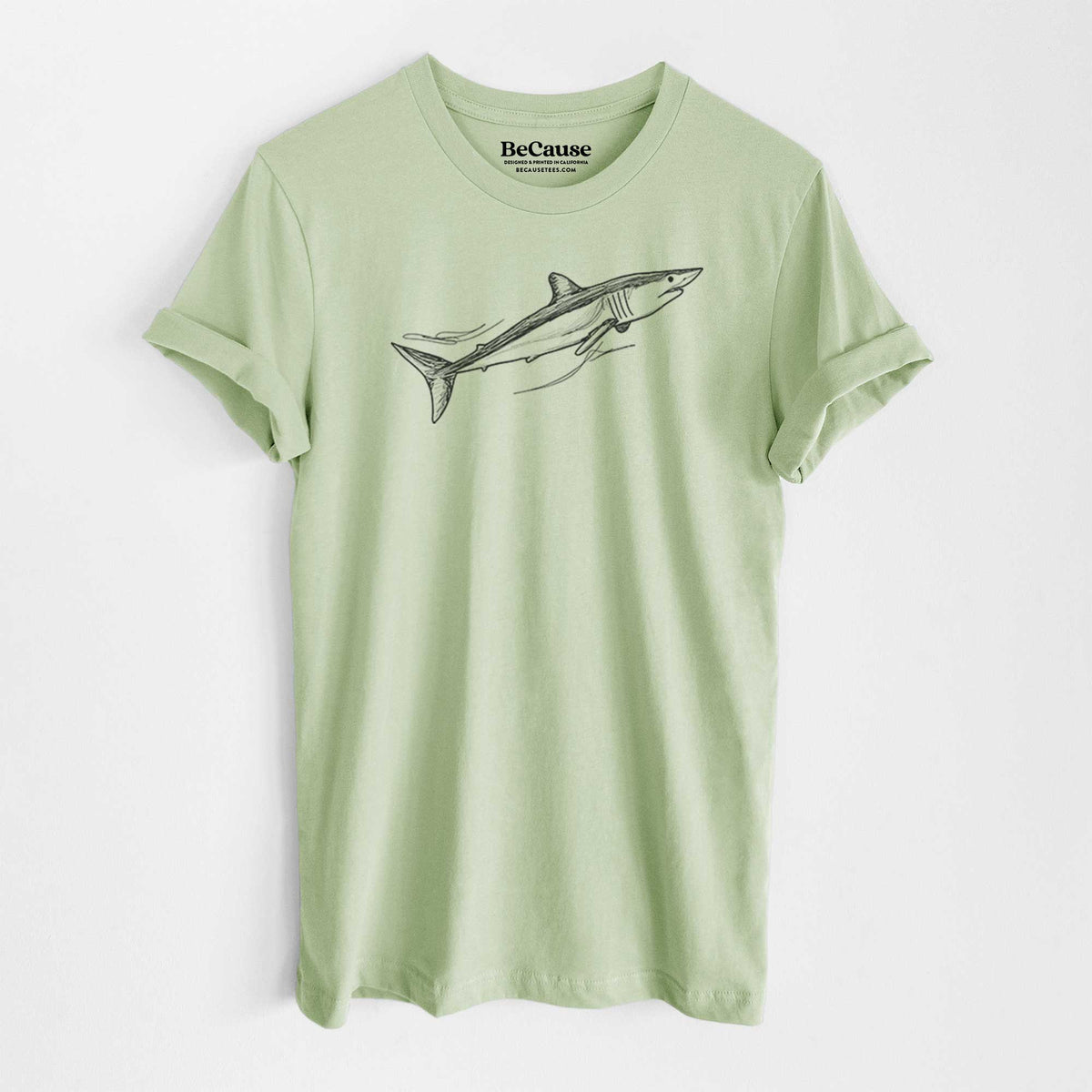Spring green lightweight cotton t-shirt laid flat, printed with a black ink illustration of a mako shark swimming.