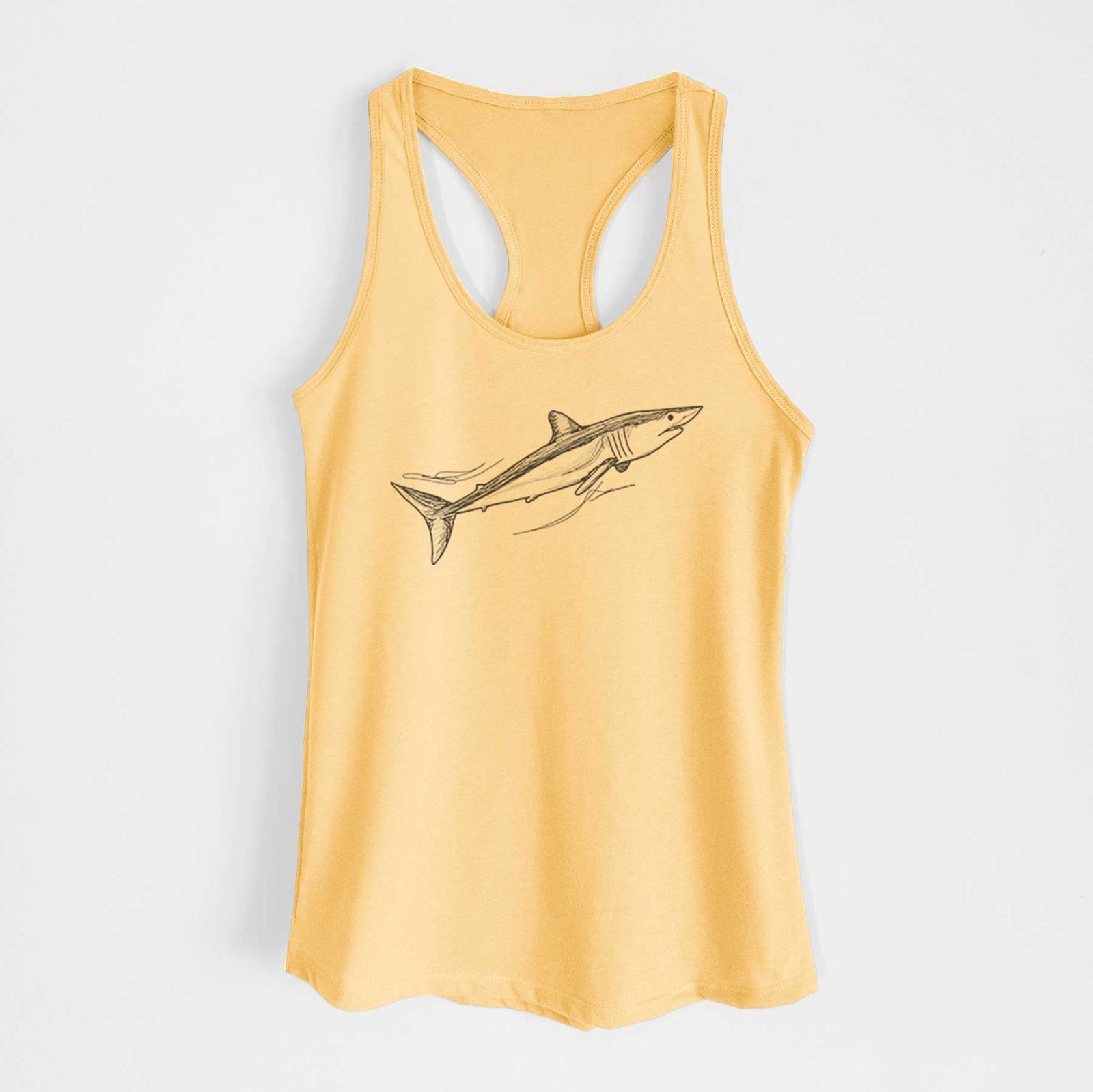 Banana cream women's racerback tank top laid flat, printed with a black ink illustration of a mako shark swimming.