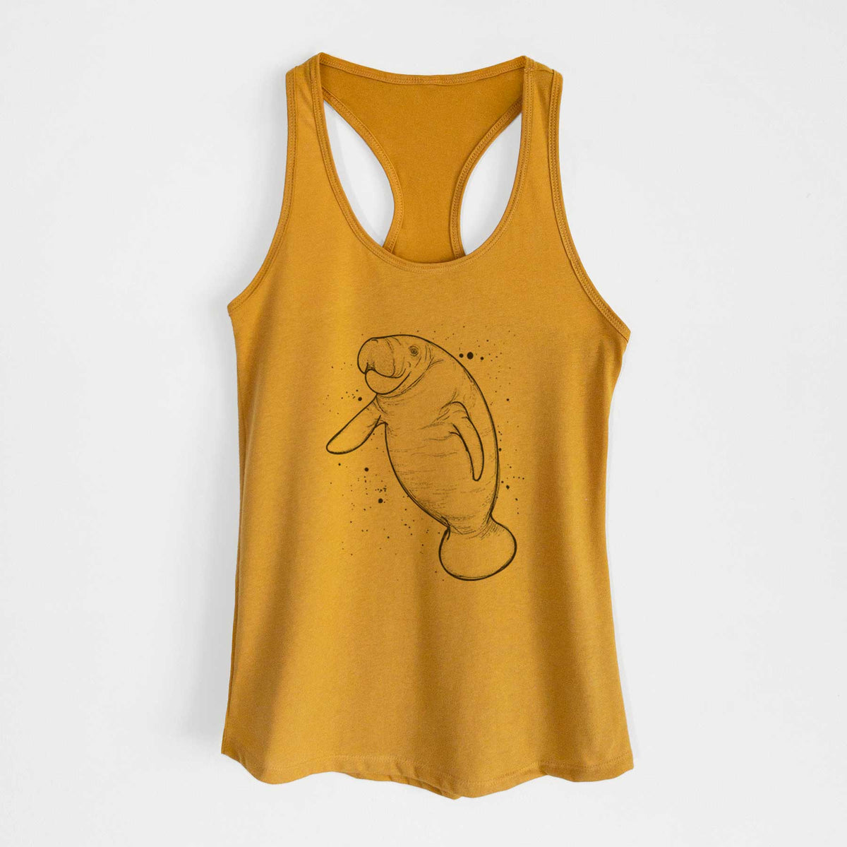 Gold women's racerback tank top laid flat, printed with a black ink line drawing of a manatee swimming, with ink splatters.