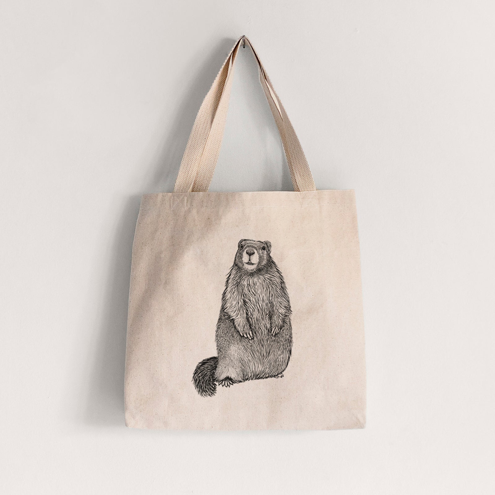Natural canvas tote bag printed with a detailed black ink illustration of a marmot standing upright.
