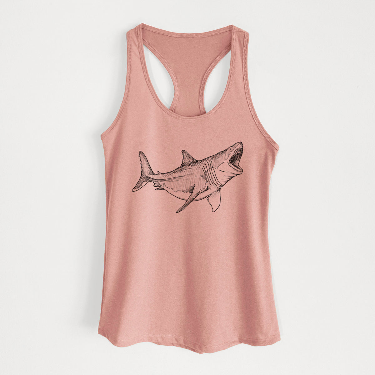 Desert pink women's racerback tank top laid flat, printed with a black ink illustration of a megalodon shark with its jaws open.