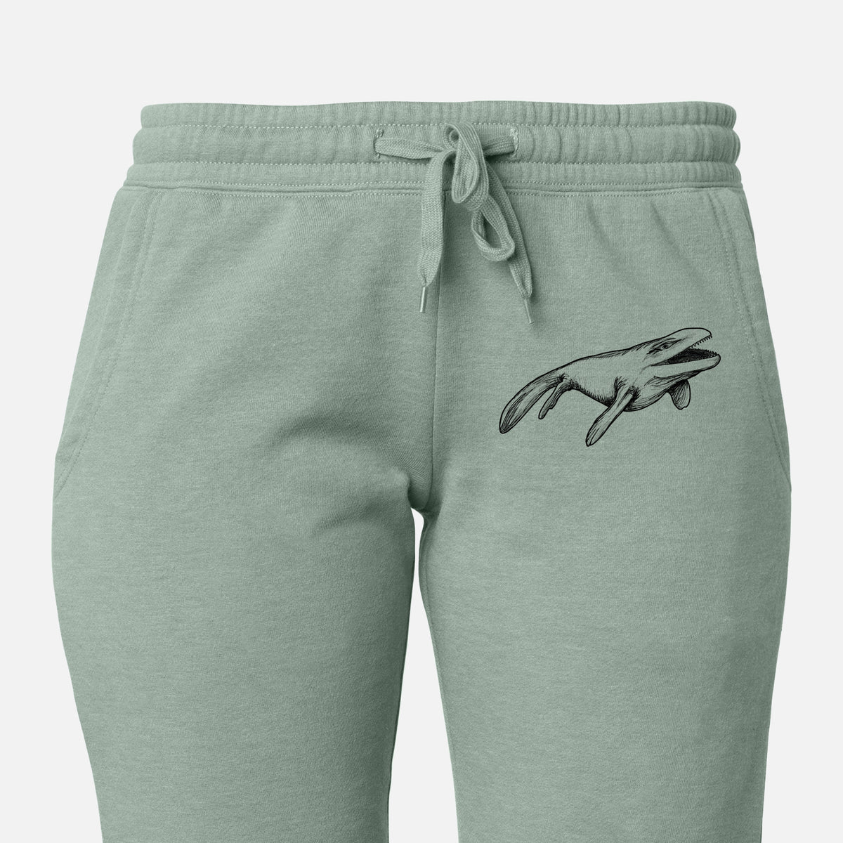 Front of sage green Cali Wave sweatpants, printed with a black ink illustration of a Mosasaur swimming on the leg.