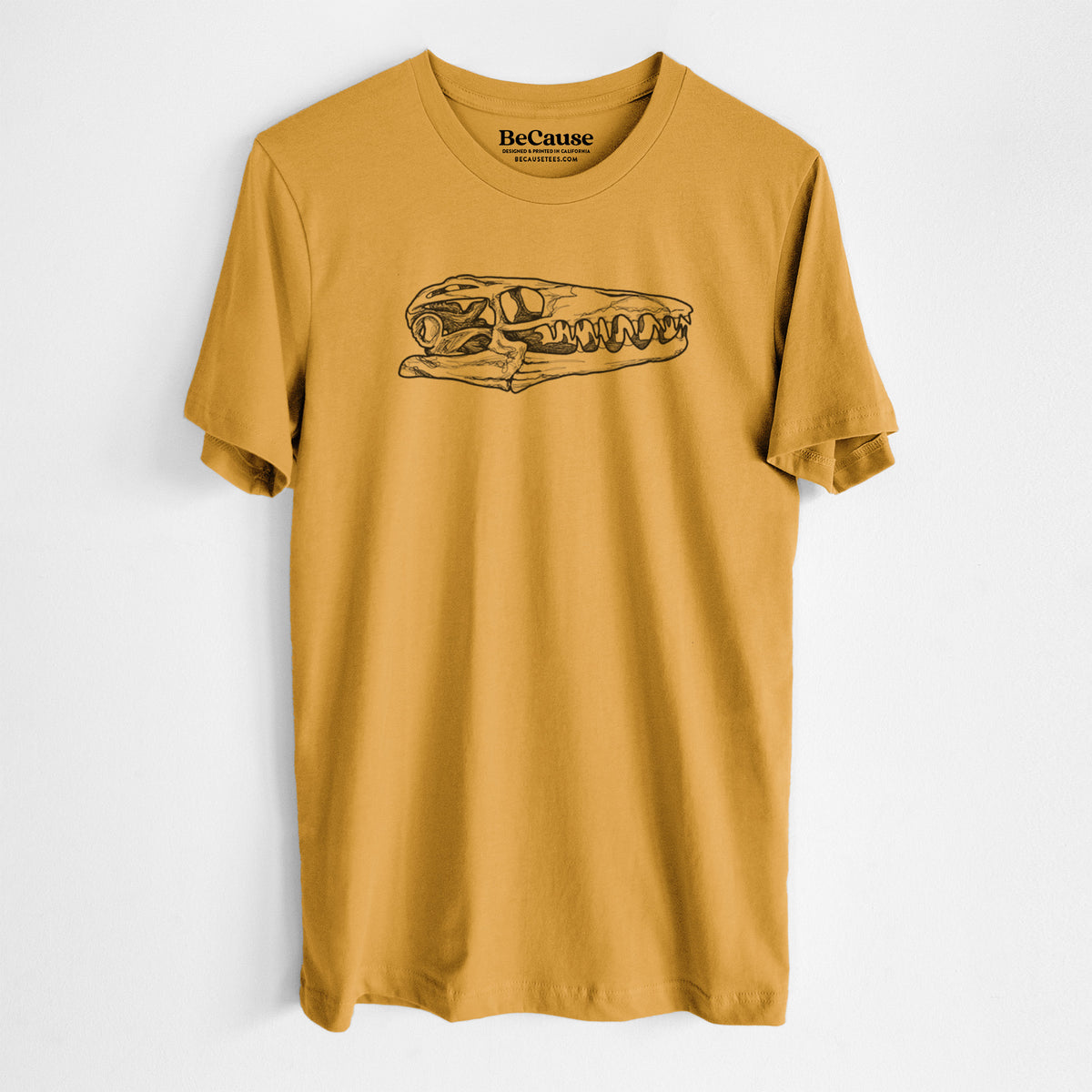 Mustard yellow lightweight cotton t-shirt laid flat, printed with a detailed black ink illustration of a Mosasaur skull.