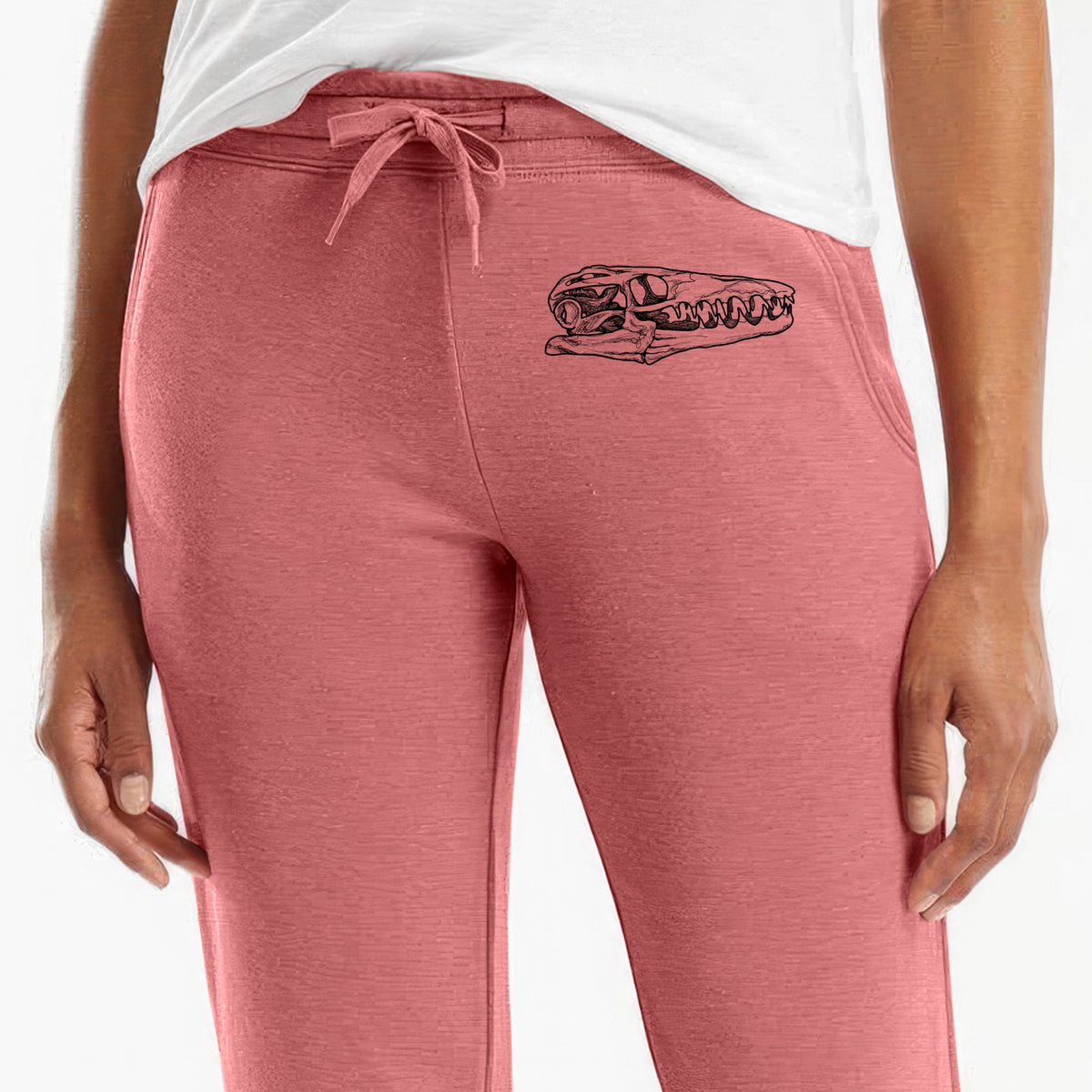 Front of dusty rose Cali Wave sweatpants, printed with a detailed black ink illustration of a Mosasaur skull on the leg.