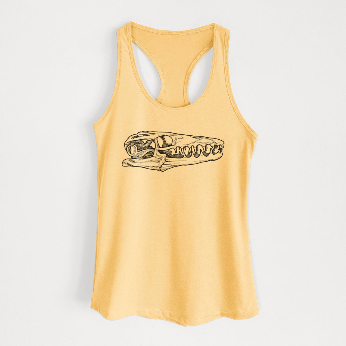 Banana cream women's racerback tank top laid flat, printed with a detailed black ink illustration of a Mosasaur skull.