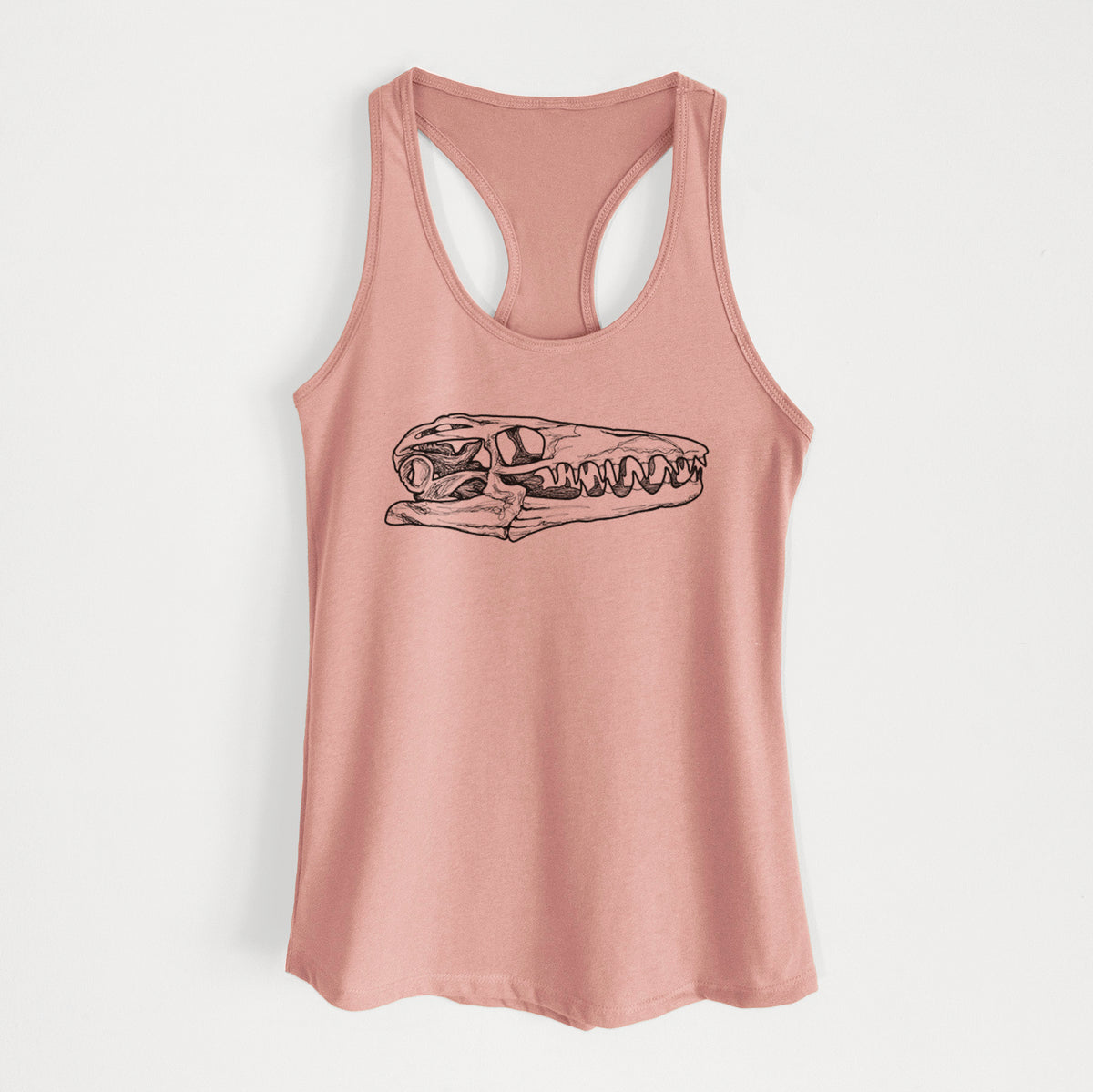 Desert pink women's racerback tank top laid flat, printed with a detailed black ink illustration of a Mosasaur skull.