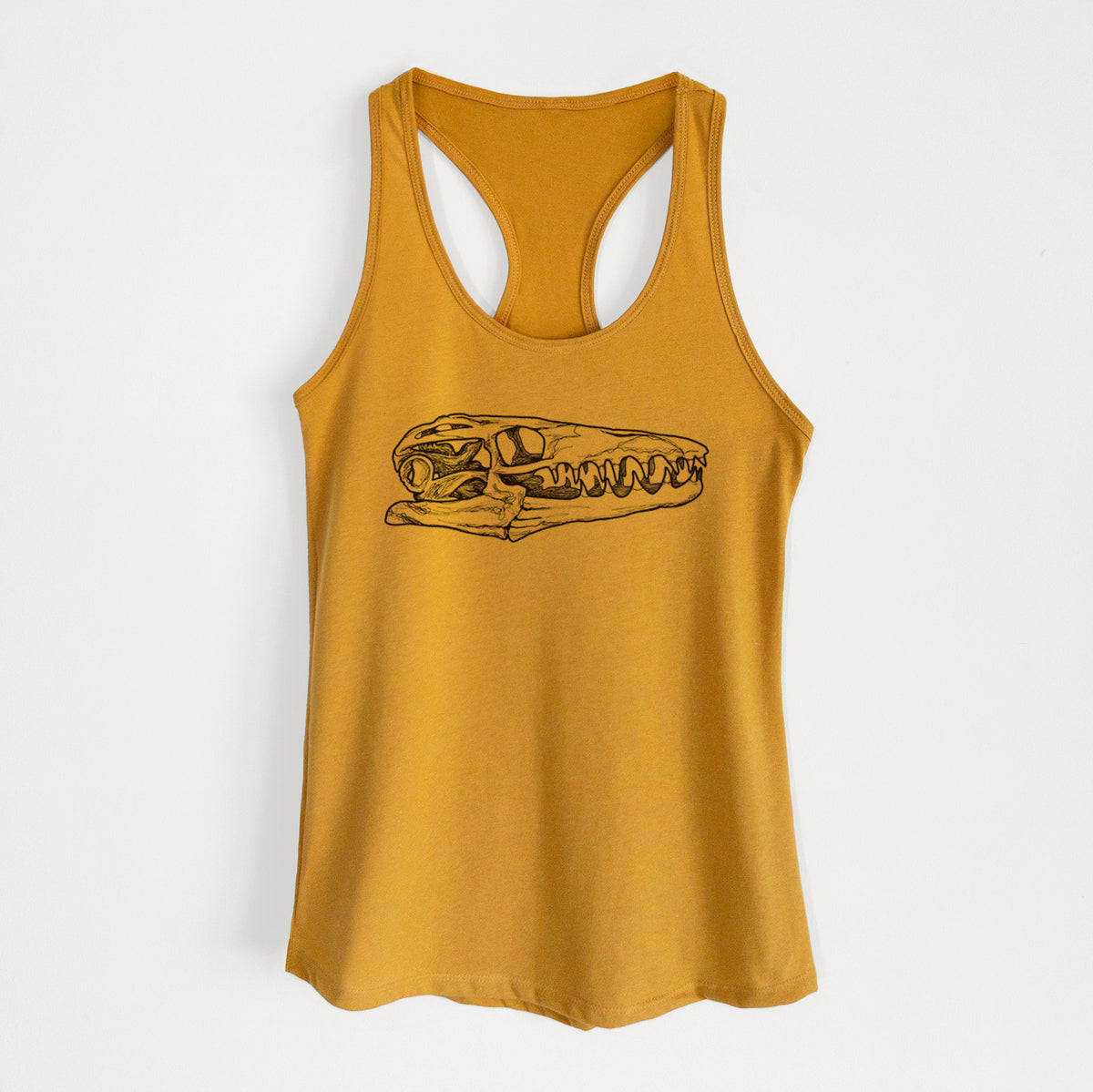 Gold women's racerback tank top laid flat, printed with a detailed black ink illustration of a Mosasaur skull.