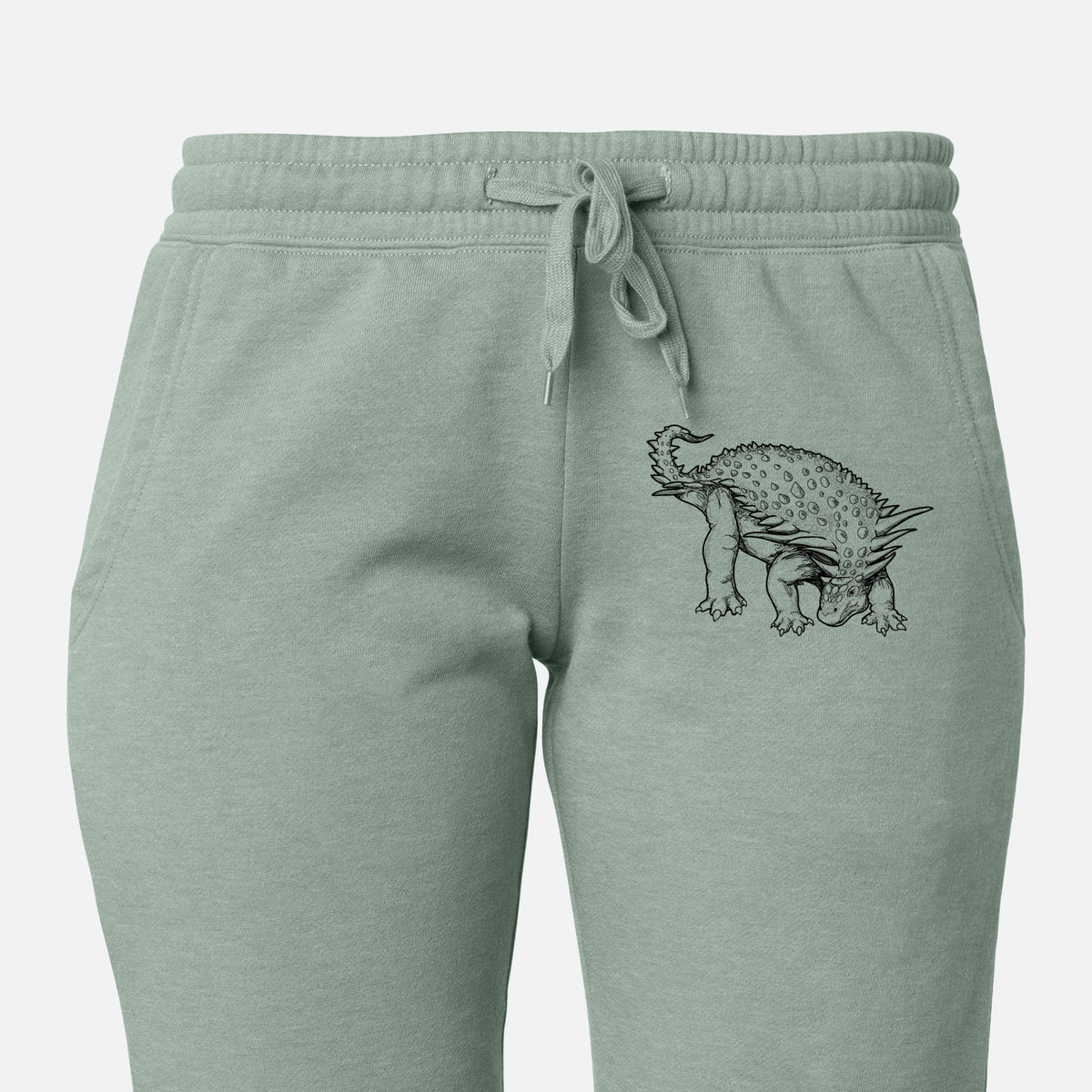 Front of sage green Cali Wave sweatpants, printed with a black ink illustration of an armored Nodosaurus on the leg.
