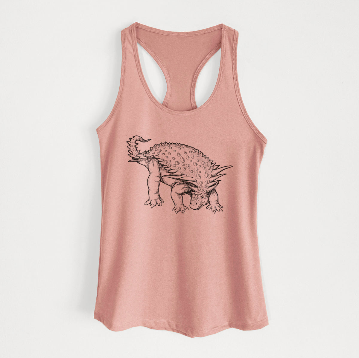 Desert pink women's racerback tank top laid flat, printed with a black ink illustration of an armored Nodosaurus.
